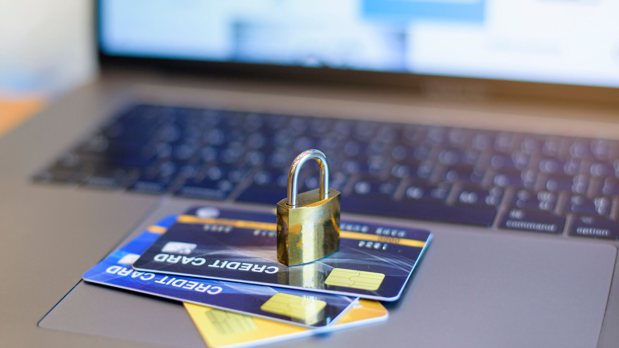 ADOBESTOCK_348602067 | Cekome Carte de crédit sous un cadenas sur un clavier d'ordinateur, illustrant la sécurité des transactions en ligne.