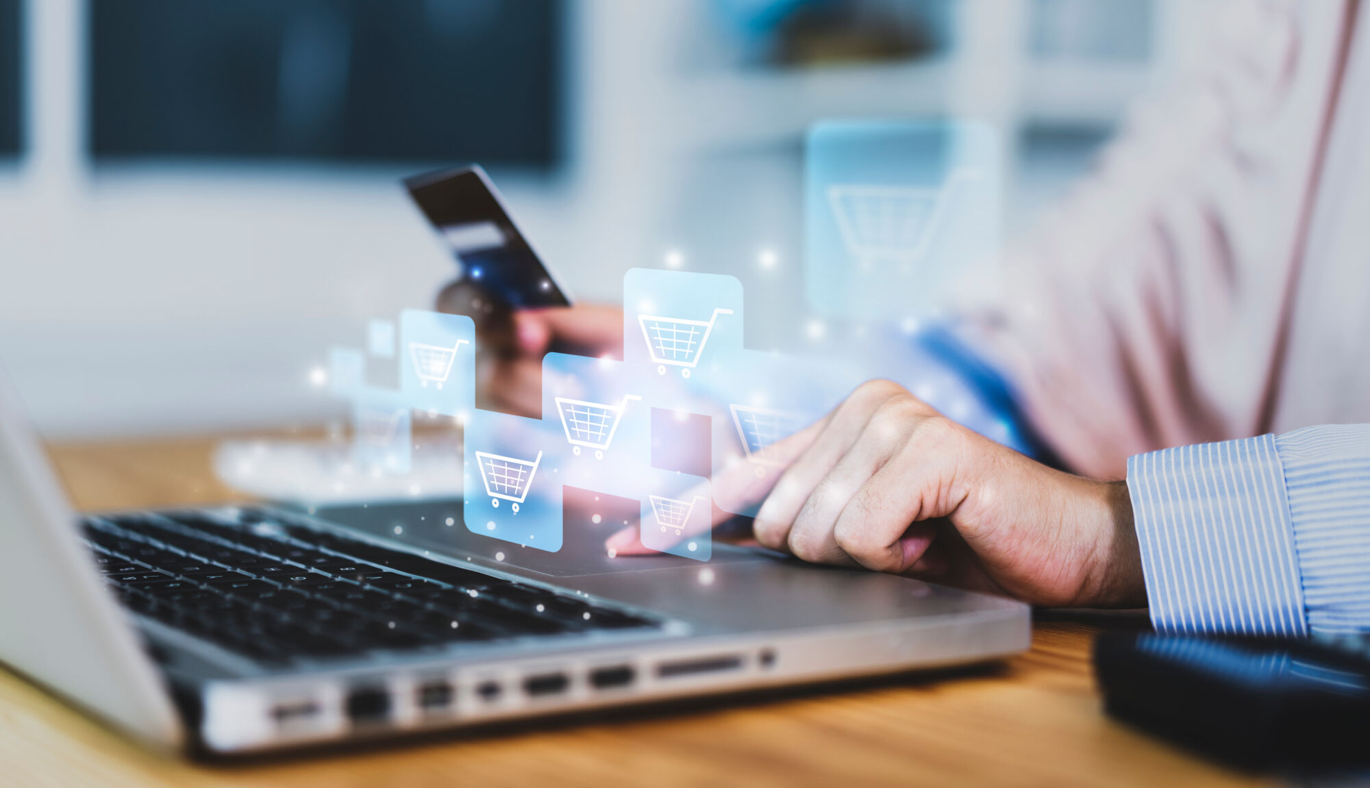 ADOBESTOCK_386084355 | Cekome Main sélectionnant un panier d'achat virtuel sur un écran d'ordinateur portable avec une carte de crédit à la main.
