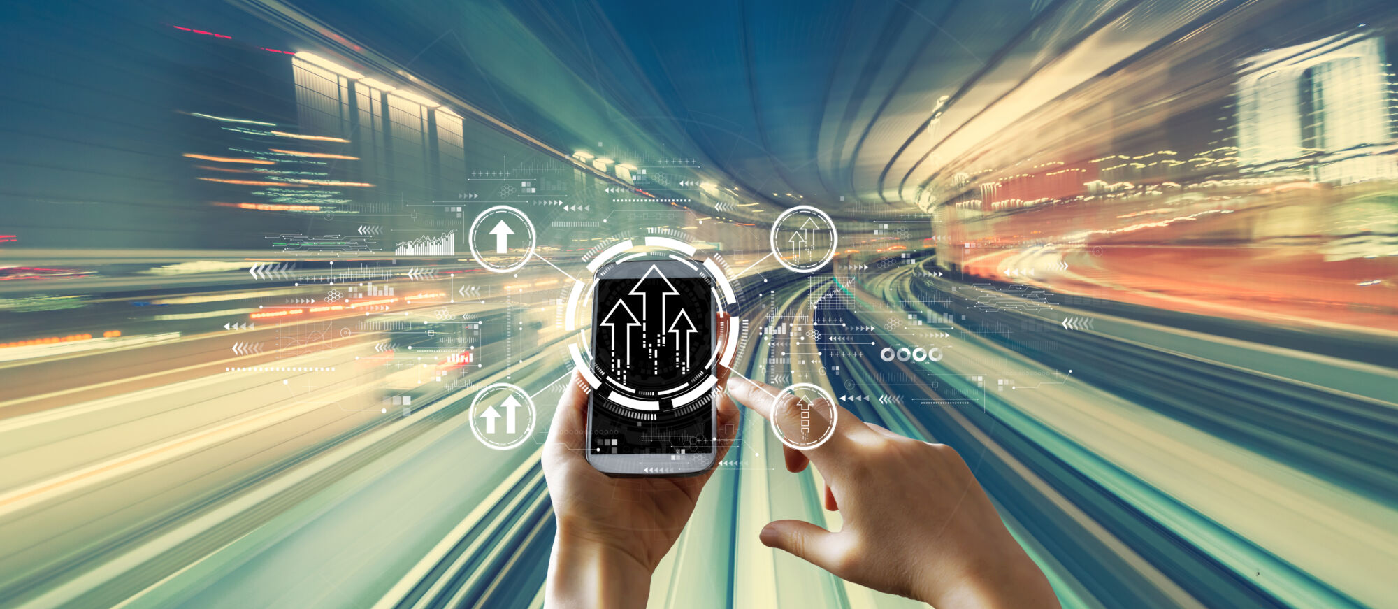 ADOBESTOCK_435918710 | Cekome Mains tenant un téléphone intelligent avec des icônes de flèches montantes sur fond de lumière en mouvement rapide.
