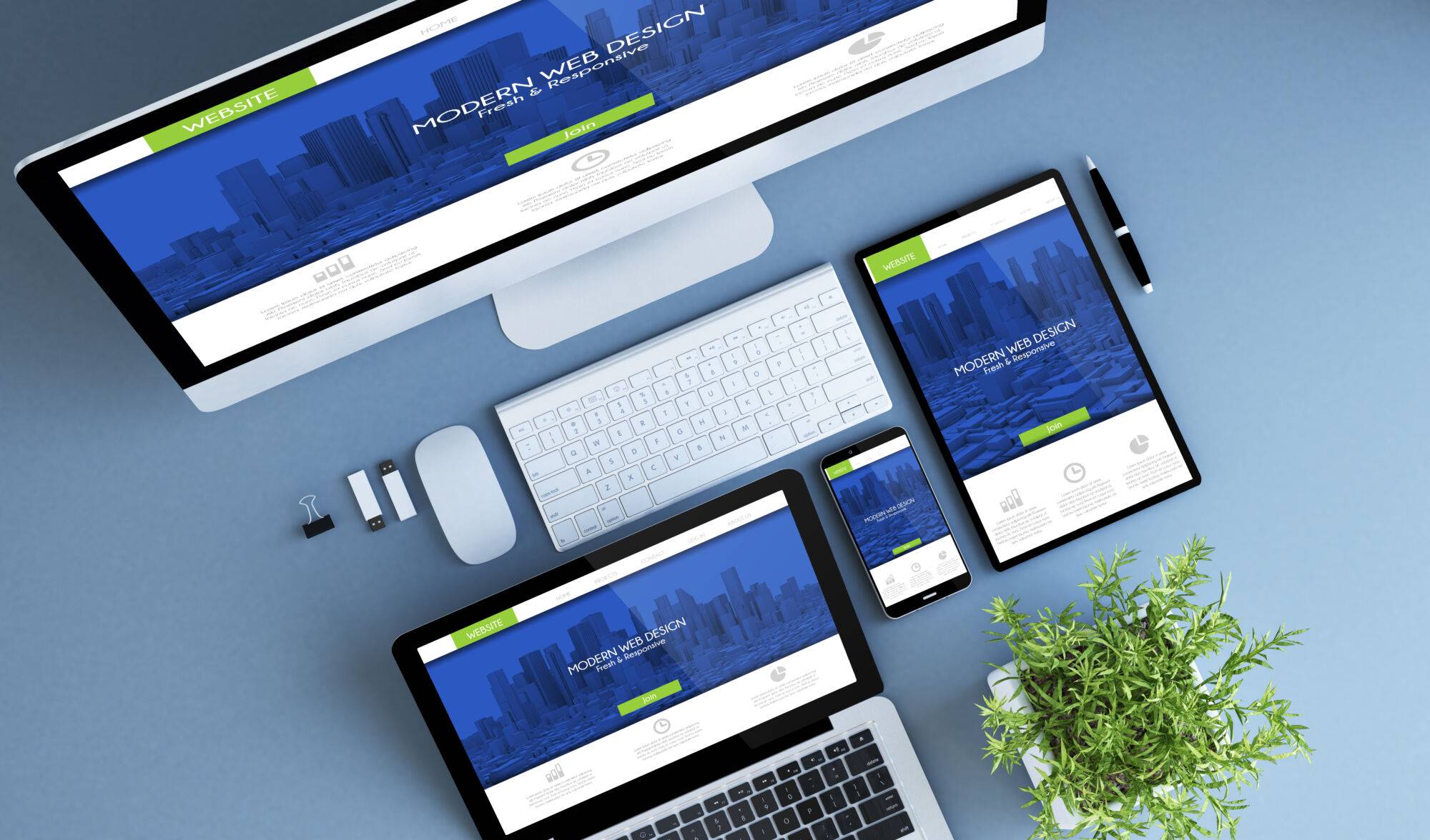 Gamme de dispositifs numériques présentant un site web de design moderne sur un bureau bleu-vert avec des accessoires de bureau.