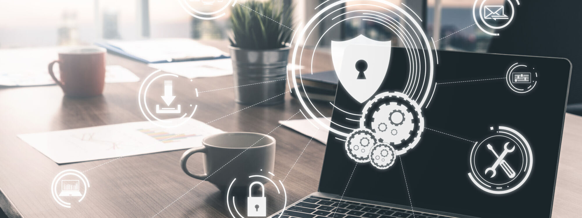 Ordinateur portable sur un bureau avec ic&ocirc;nes de s&eacute;curit&eacute; num&eacute;rique et cryptage dans un espace de travail moderne.