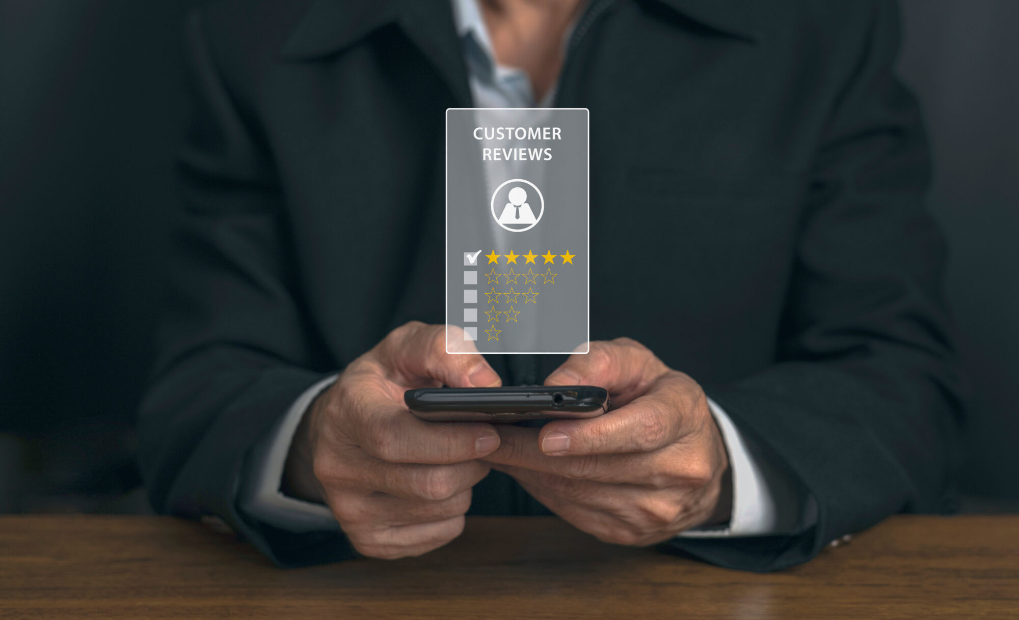 ADOBESTOCK_572707401 | Cekome Homme d'affaires consultant les avis clients étoilés sur un smartphone.