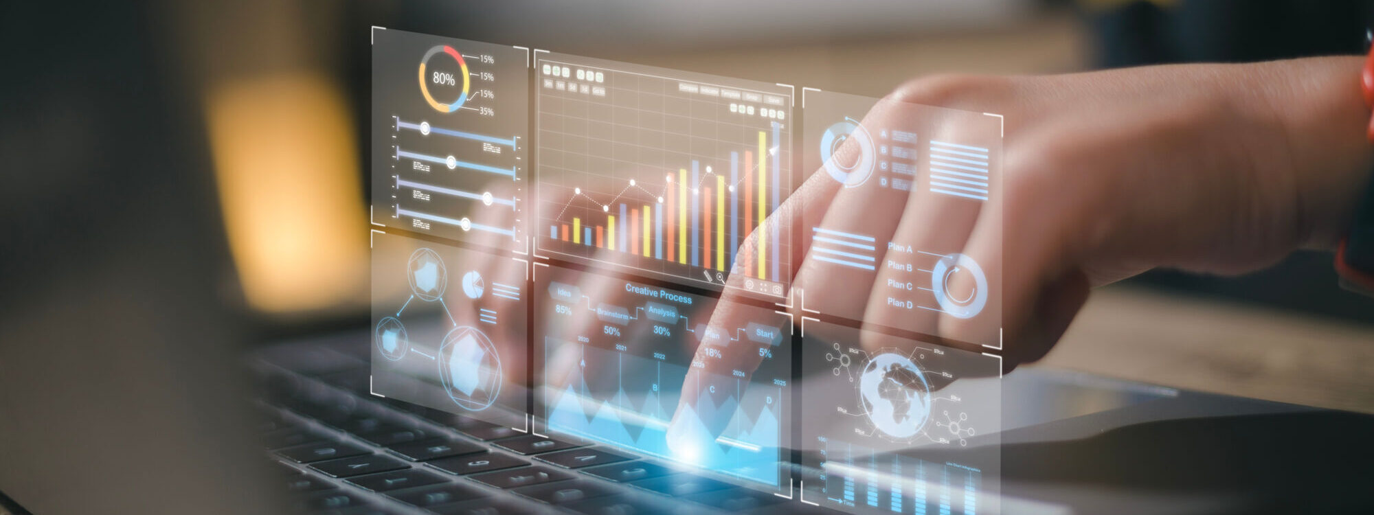 Mains tapant sur un ordinateur portable avec des graphiques d'analyse financi&egrave;re holographiques.
