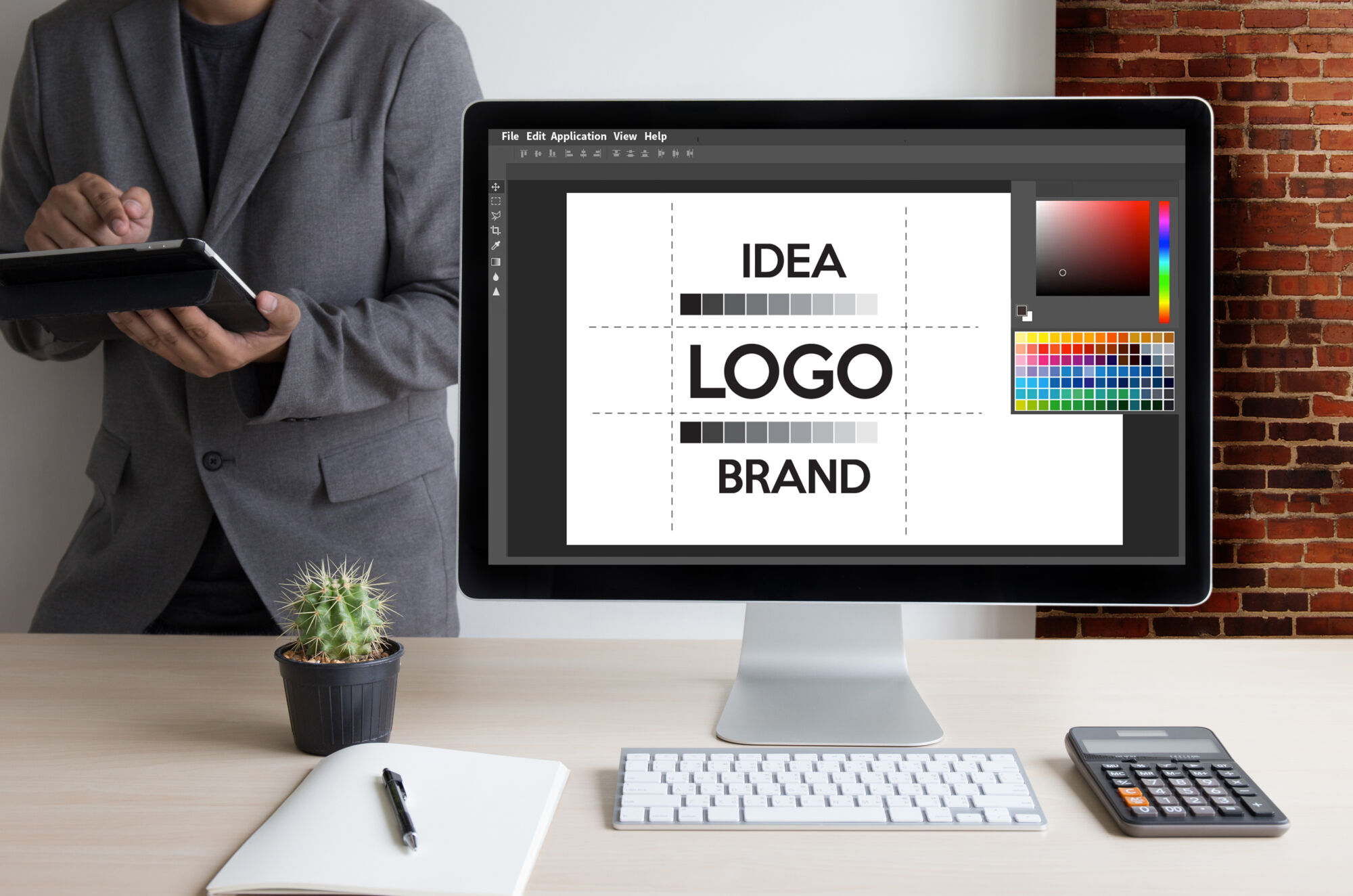 ADOBESTOCK_173186565 | Cekome Écran d'ordinateur affichant un logiciel de conception graphique avec des mots 'IDEA', 'LOGO', 'BRAND' sur le moniteur.