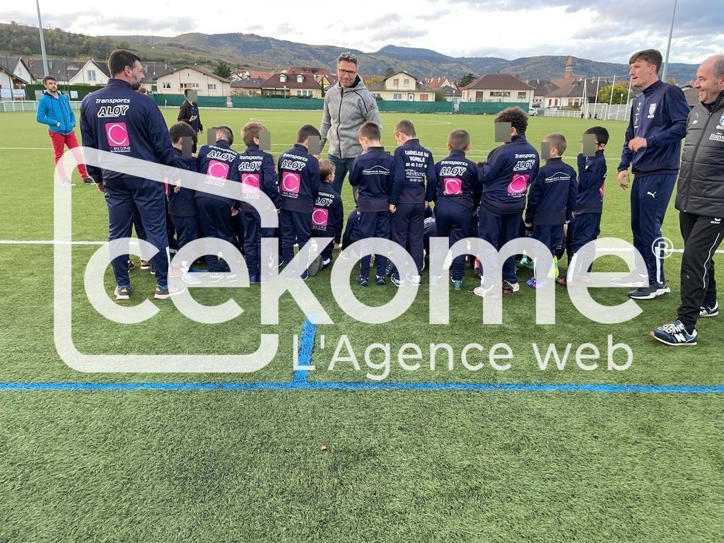 5 4 4 | Cekome Équipe de jeunes footballeurs écoutant leur entraîneur sur un terrain de sport.