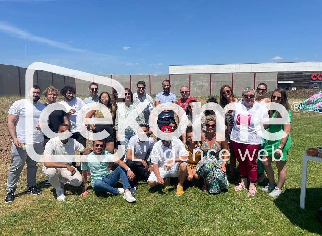 Photo de groupe en ext&eacute;rieur sur la pelouse devant le b&acirc;timent de l'entreprise Cekome.