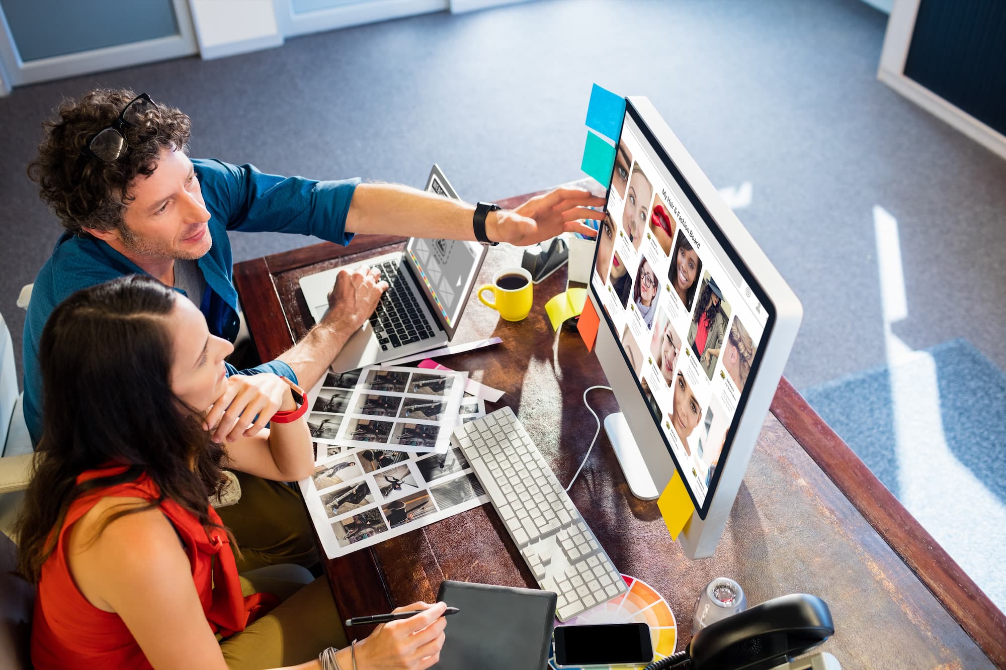 ADOBESTOCK_141372504 | Cekome Deux collègues discutant devant un écran d'ordinateur avec des images de personnes.