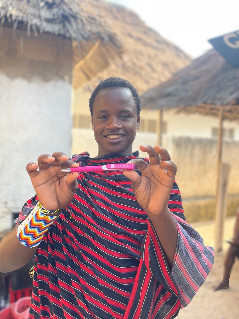 3 2 2 | Cekome Jeune homme présentant un stylo rose avec sourire.