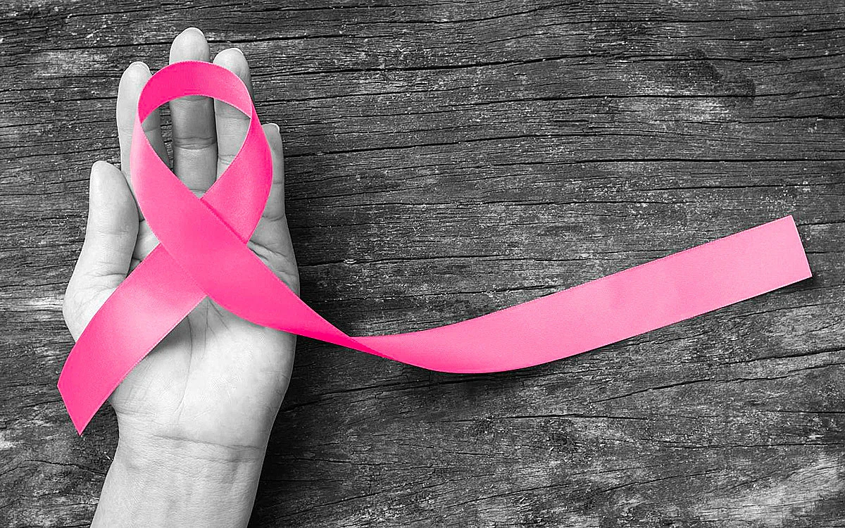 3 8 1 | Cekome Main tenant un ruban rose symbolisant le soutien à la lutte contre le cancer du sein.