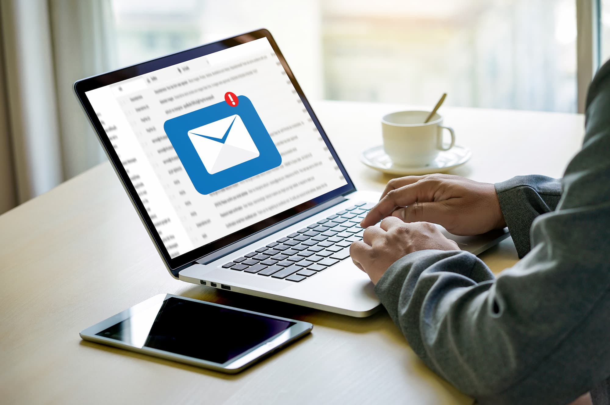 ADOBESTOCK_184237958 | Cekome Utilisateur travaillant sur un ordinateur portable avec une notification d'email urgent sur l'écran.