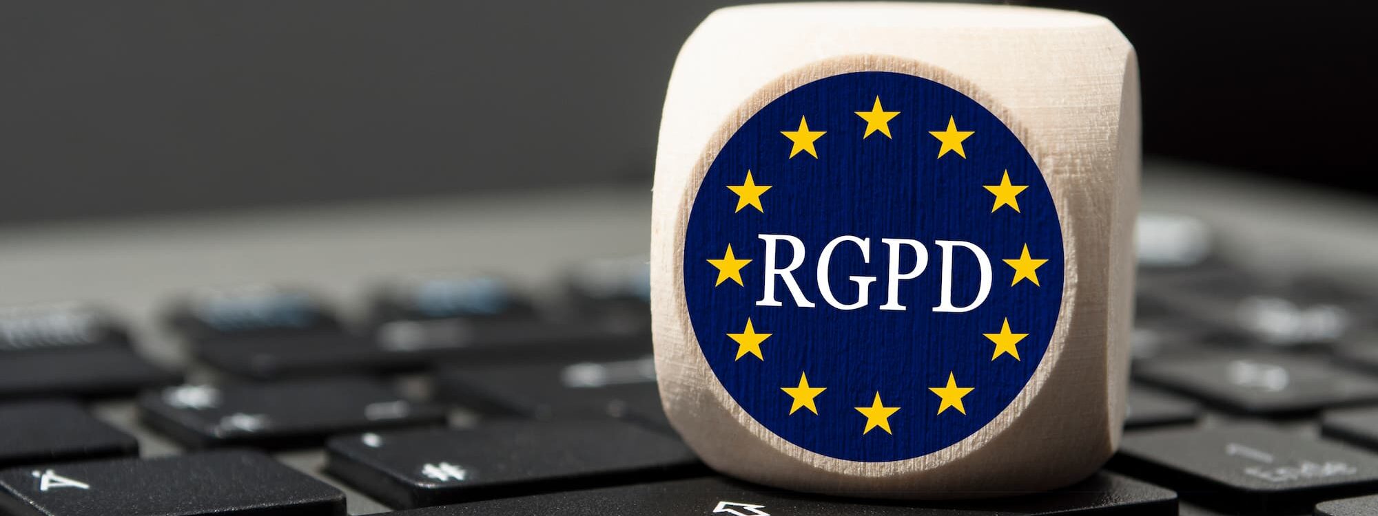 ADOBESTOCK_284676577 2000X750 | Cekome Dé déposé sur un clavier d'ordinateur avec le symbole RGPD pour représenter la conformité à la réglementation européenne.