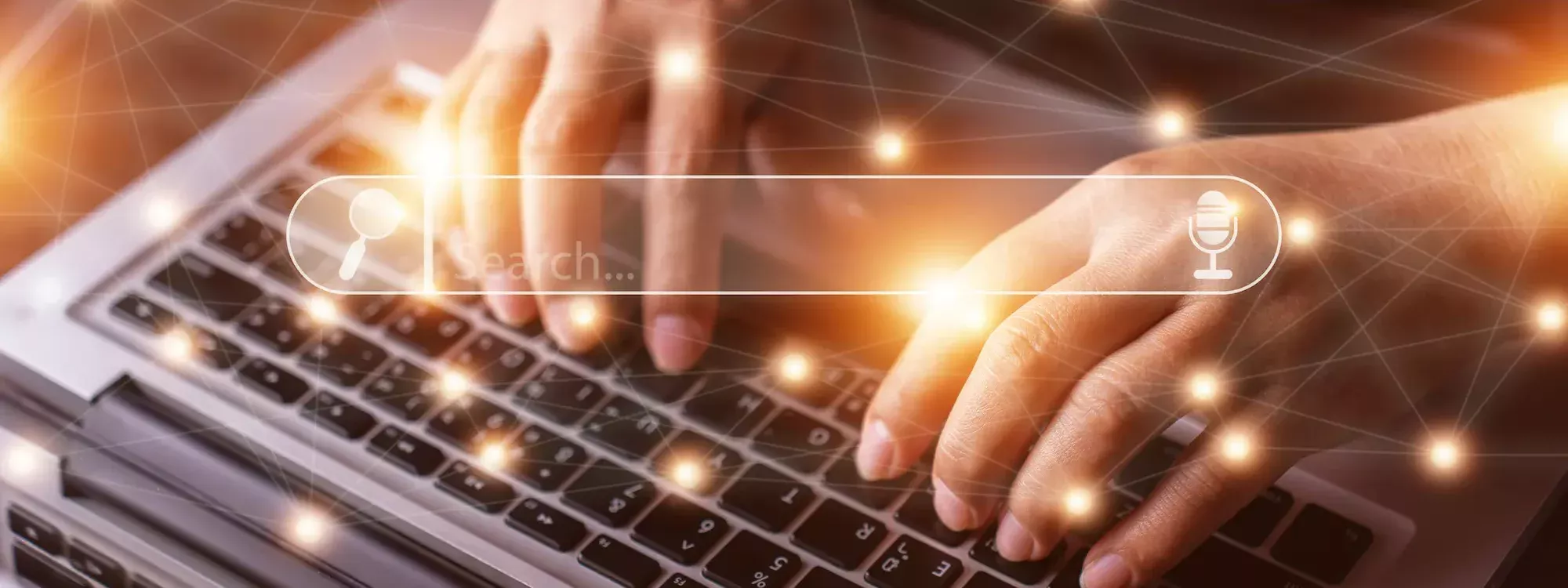 Main tapant sur un clavier d'ordinateur portable avec des icônes de recherche et de reconnaissance vocale