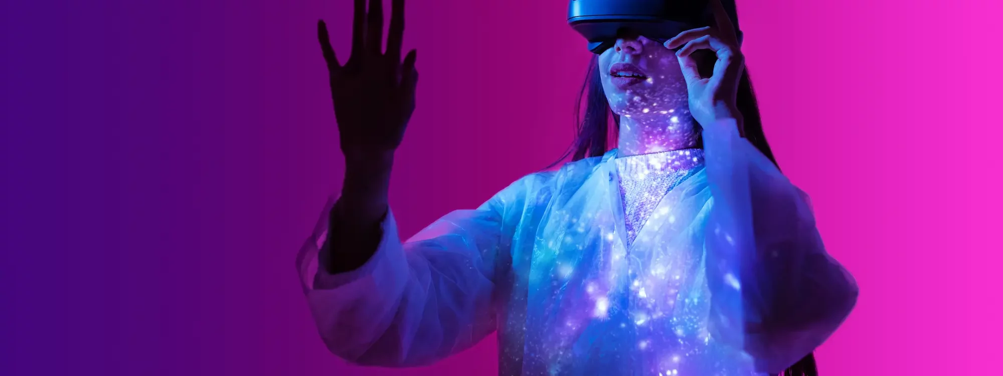 ADOBESTOCK_562982183 2000X750 | Cekome Femme interagissant avec un casque de réalité augmentée dans une ambiance futuriste avec des lumières violettes et bleues
