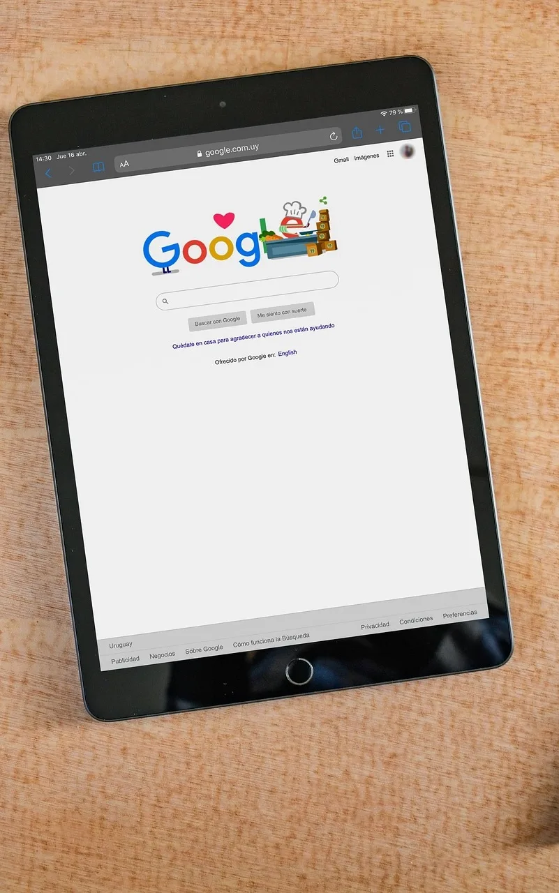 Tablette affichant la page d'accueil de Google avec un doodle spécial sur un bureau en bois