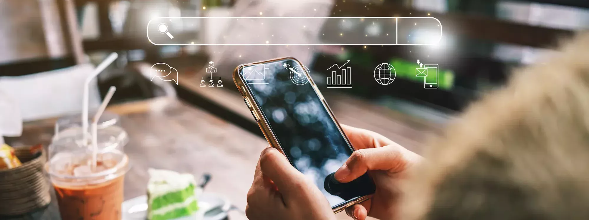 Personne utilisant un smartphone dans un café avec des icônes de recherche et de marketing numérique en surimpression