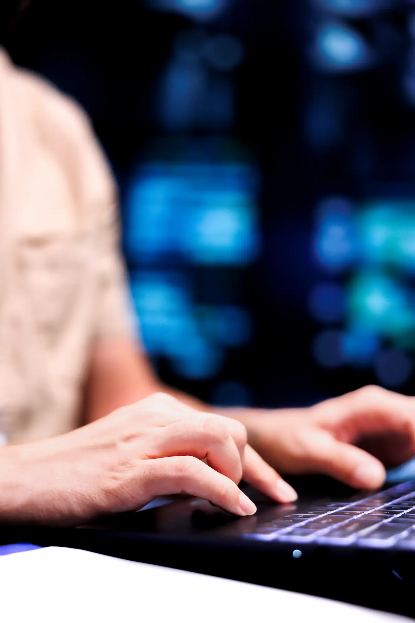 CLOSE UP SHOT SERVICEMAN DEALING WITH DATA CENTER SYSTEM FAILURES USING LAPTOP ORDER SERVERS WITH HIGH AVAILABILITY FEATURES MINIMIZE DOWNTIME PREVENT CRASHES | Cekome Gros plan sur des mains tapant sur un clavier d'ordinateur avec des écrans flous en arrière-plan.
