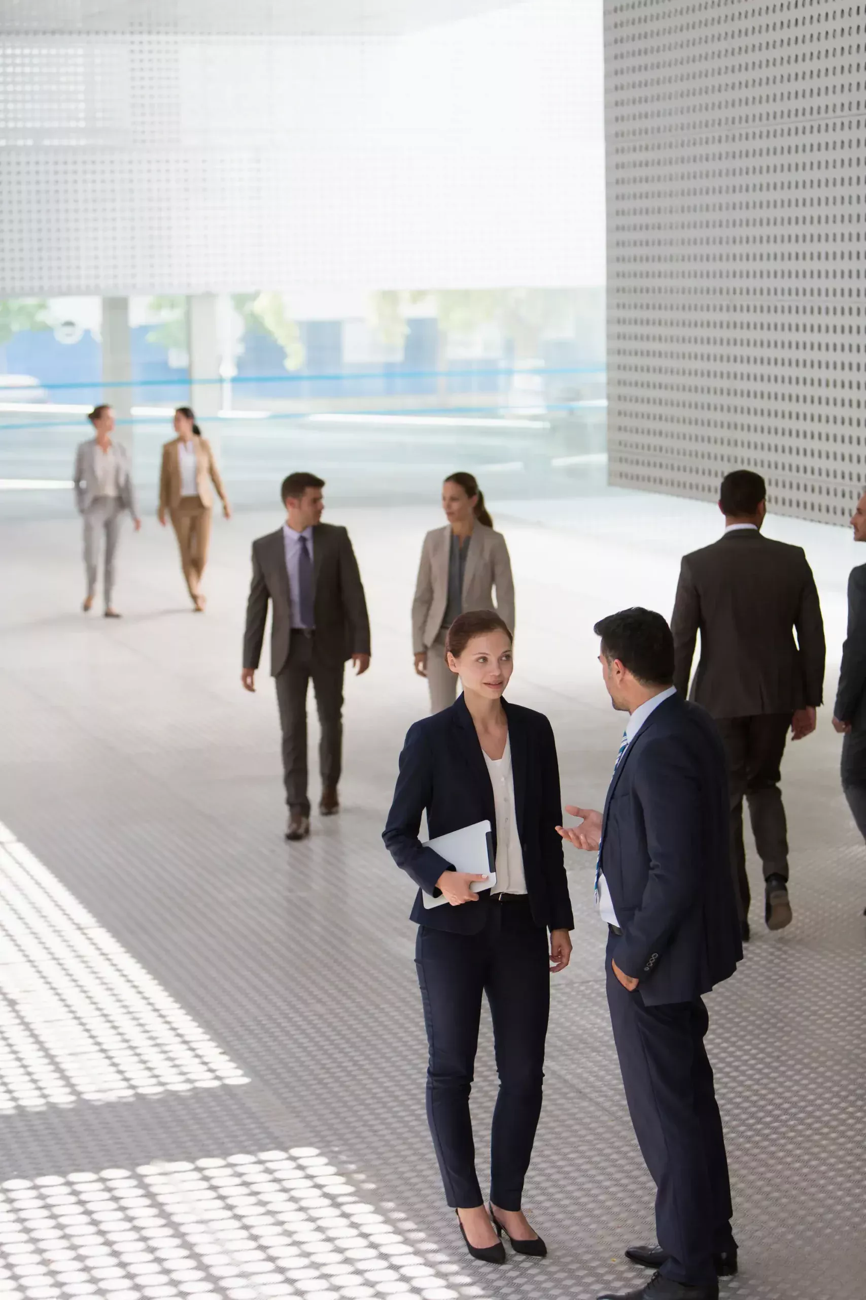 ADOBESTOCK_383185269 SCALED | Cekome Personnes en costume discutant dans un hall moderne