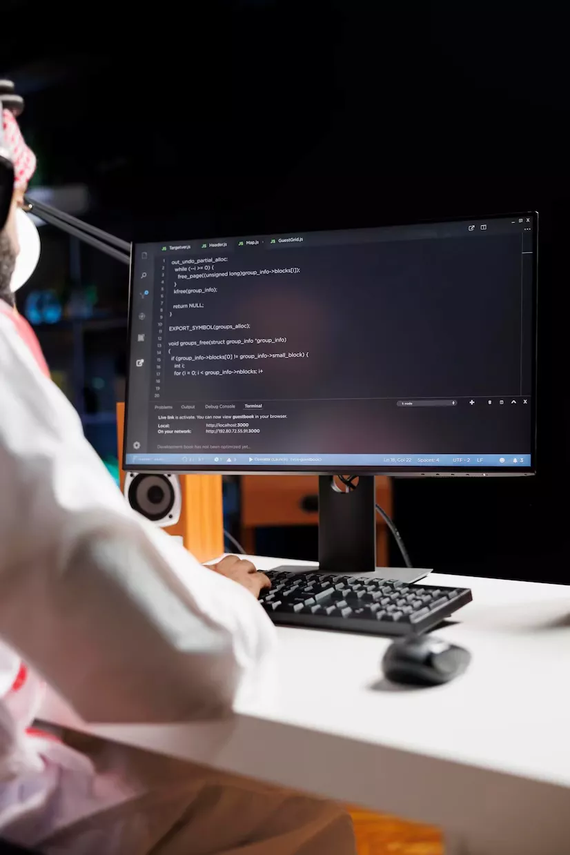 COMPUTER MONITOR SHOWING SOURCE CODE_482257 76210 | Cekome Développeur travaillant sur du code informatique affiché sur un écran, assis à un bureau avec un clavier et une souris, en arrière-plan sombre.