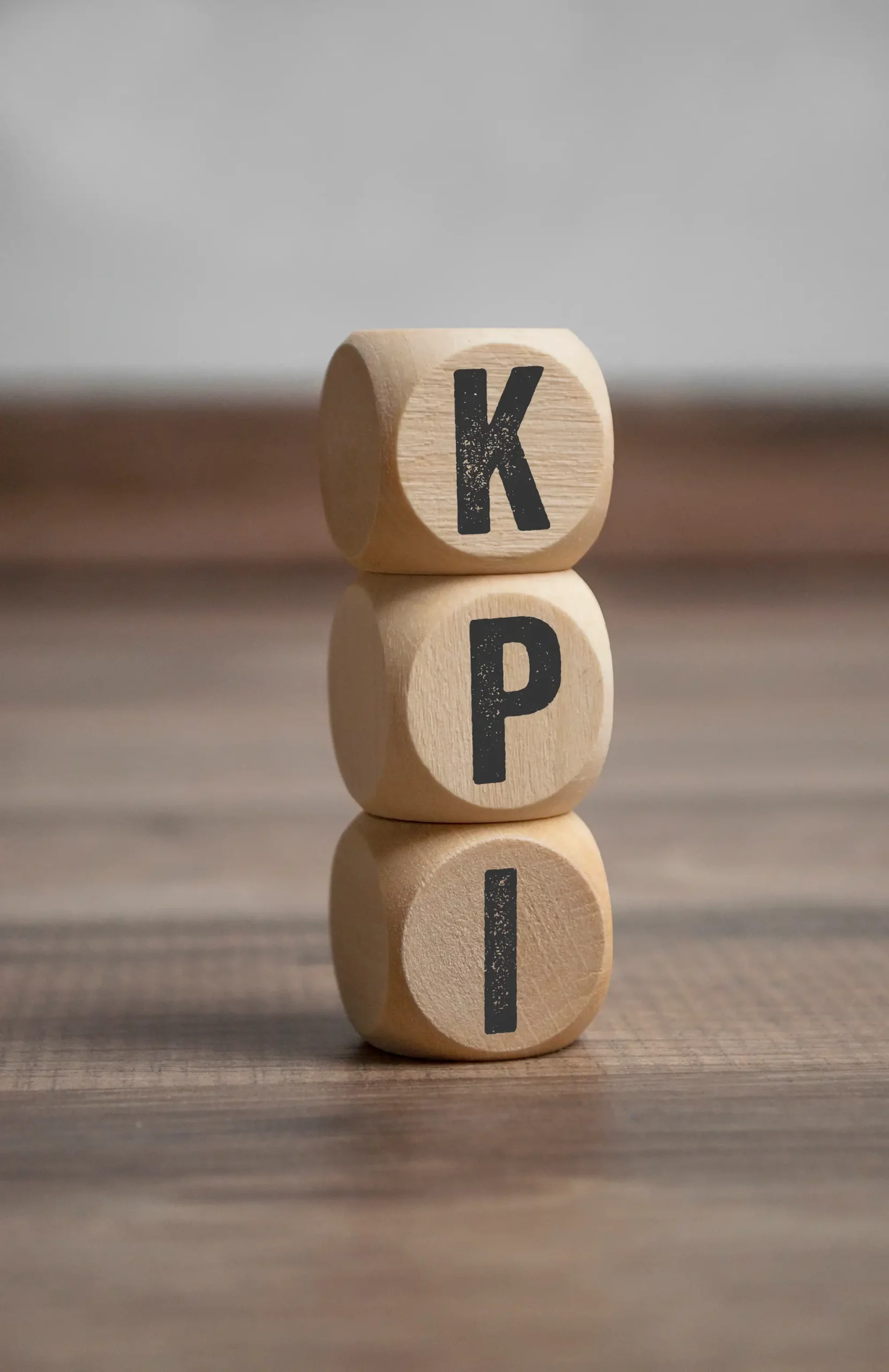 ADOBESTOCK_276212104 SCALED | Cekome Dés en bois empilés formant l'acronyme KPI sur une table en bois
