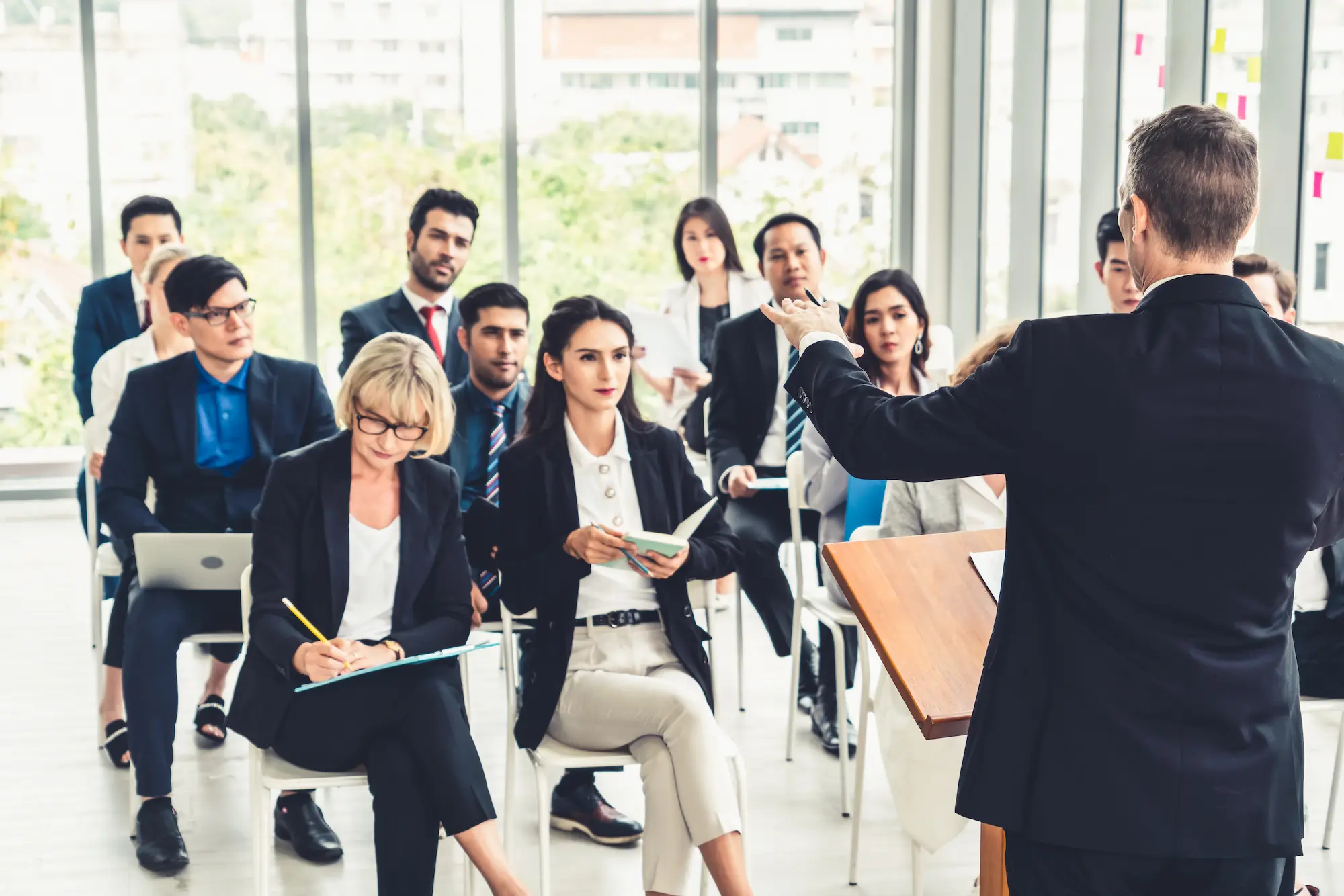 Conférencier s'adressant à un groupe de professionnels en formation dans une salle moderne