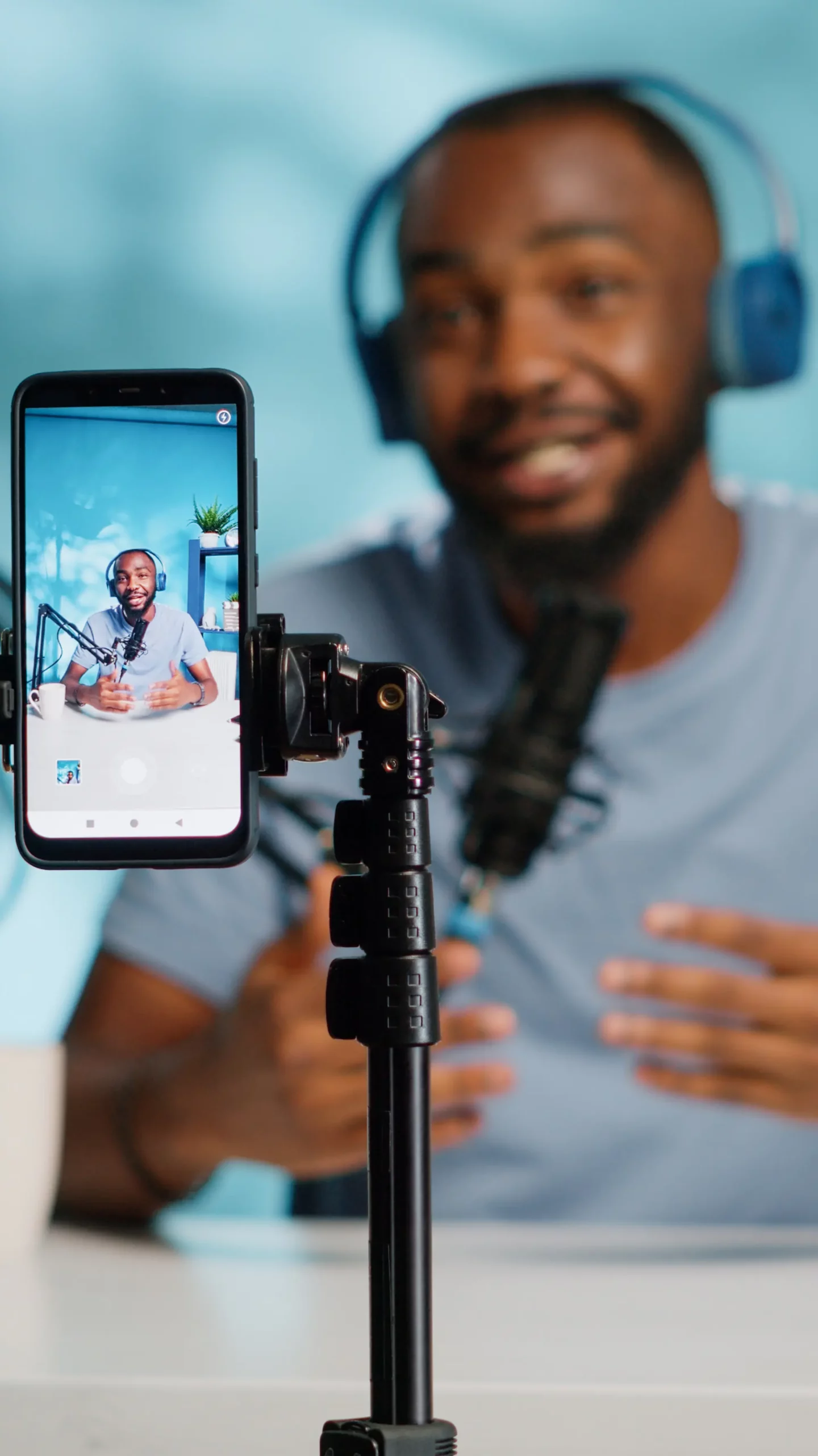 Homme enregistrant un podcast vidéo avec un smartphone et un micro