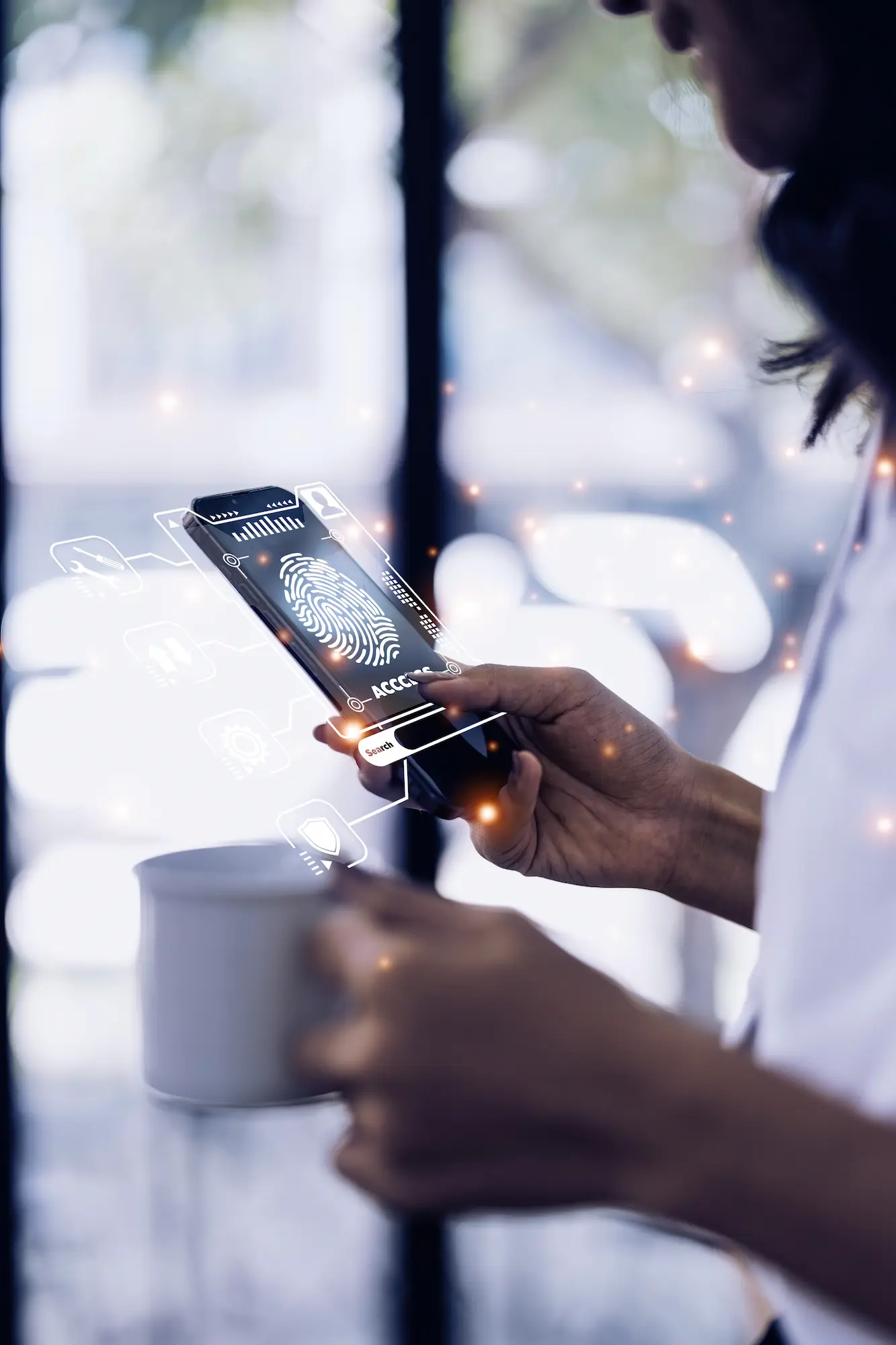 ADOBESTOCK_536907511 | Cekome Femme utilisant l'authentification par empreinte digitale sur un smartphone, tenant une tasse de café, avec une interface de sécurité numérique en surimpression.