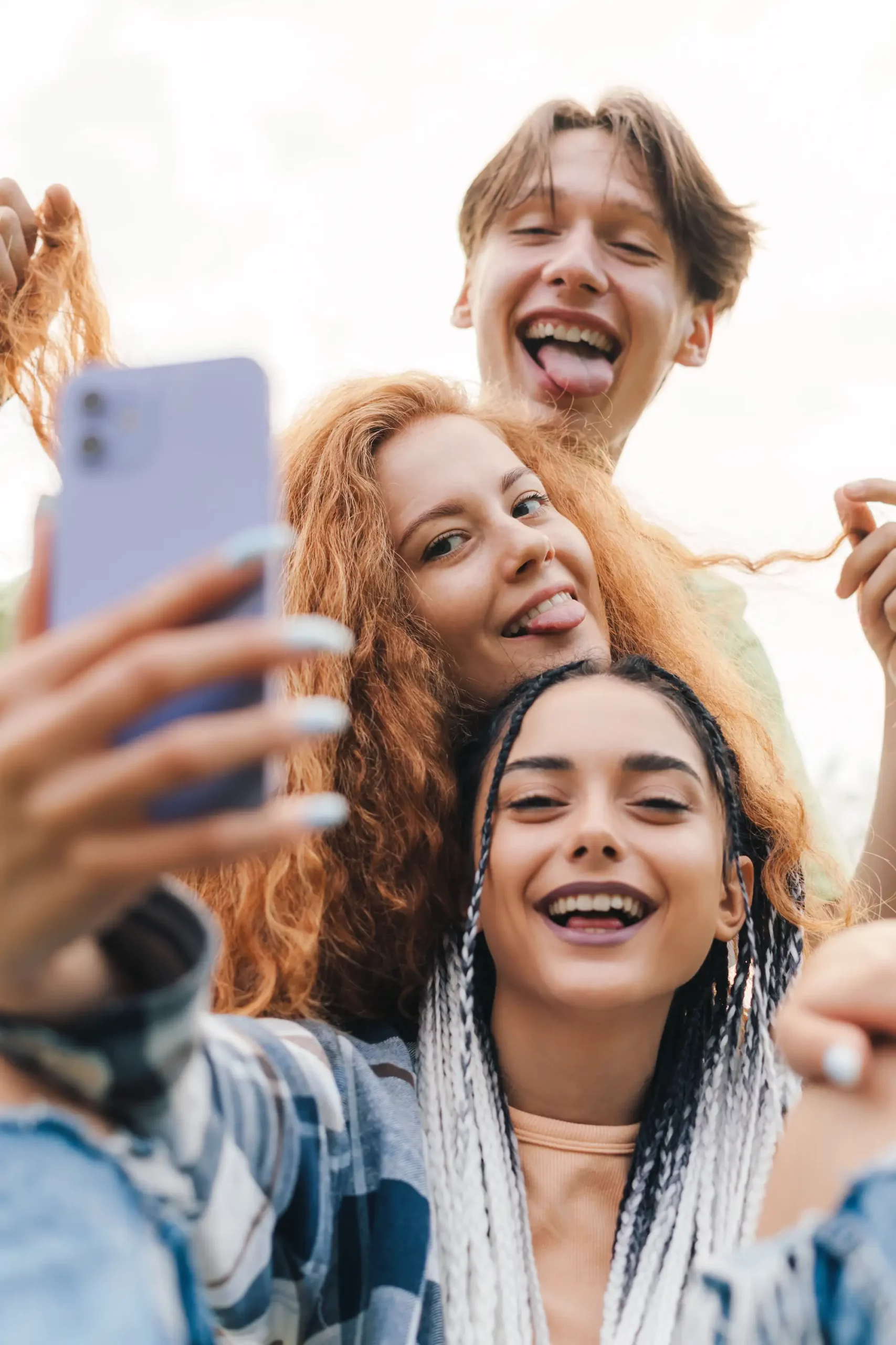 ADOBESTOCK_541505008 SCALED | Cekome Trois amis souriants prenant un selfie ensemble en extérieur