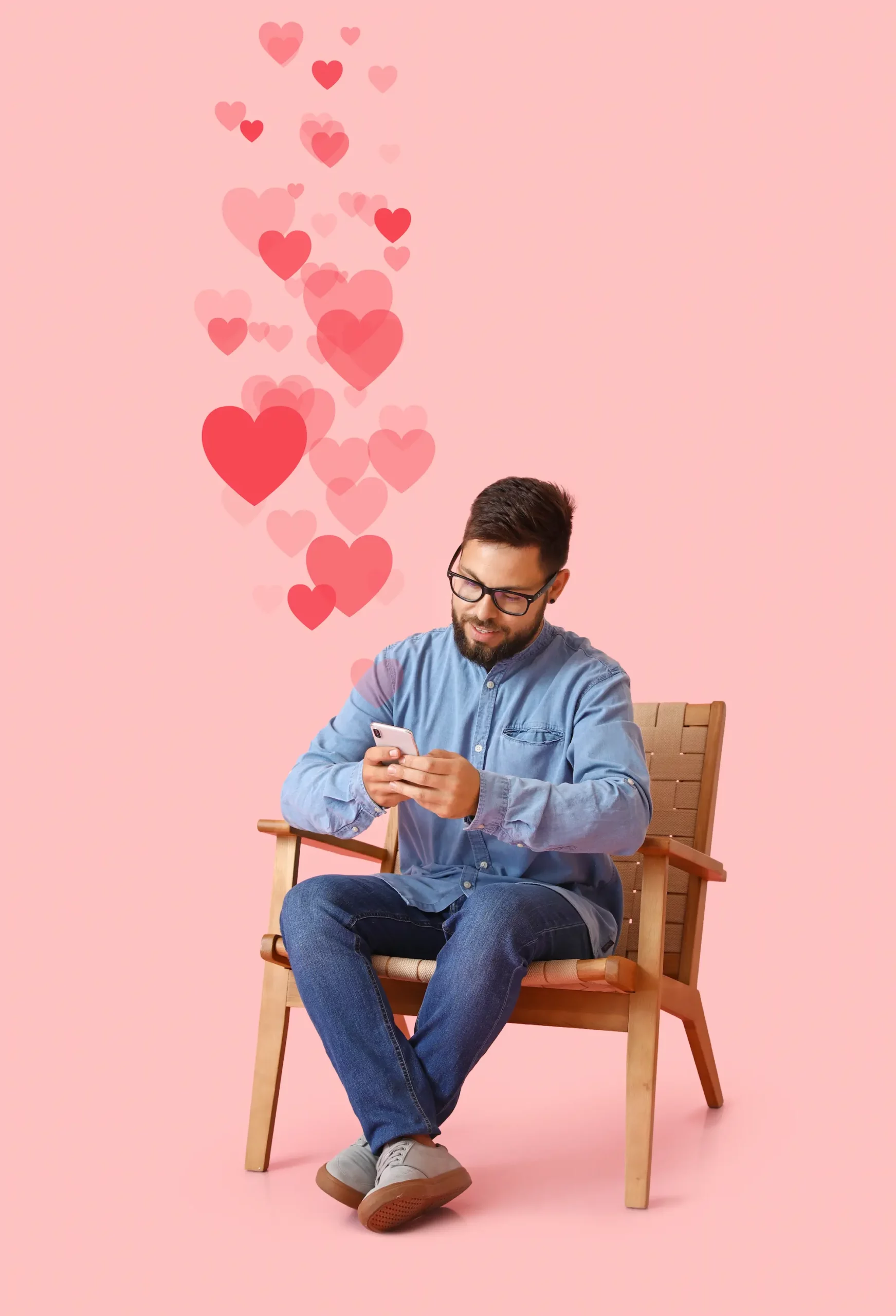 ADOBESTOCK_480089295 SCALED | Cekome Homme assis envoyant des messages avec des icônes de cœurs flottant au-dessus de son téléphone