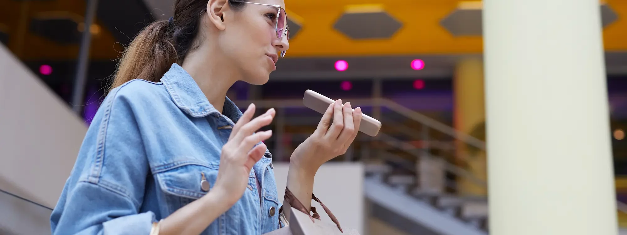 Femme avec des sacs de shopping parlant dans son smartphone