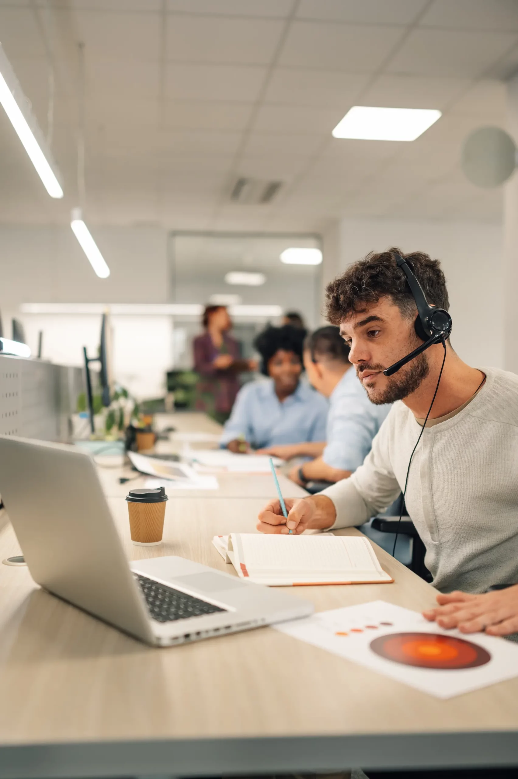 Homme avec un casque travaillant sur un ordinateur portable dans un bureau partagé