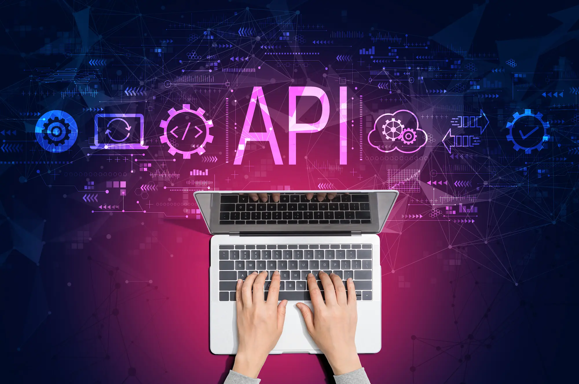 ADOBESTOCK_488651007 | Cekome Mains tapant sur un ordinateur portable avec le mot API et des icônes technologiques en arrière-plan.