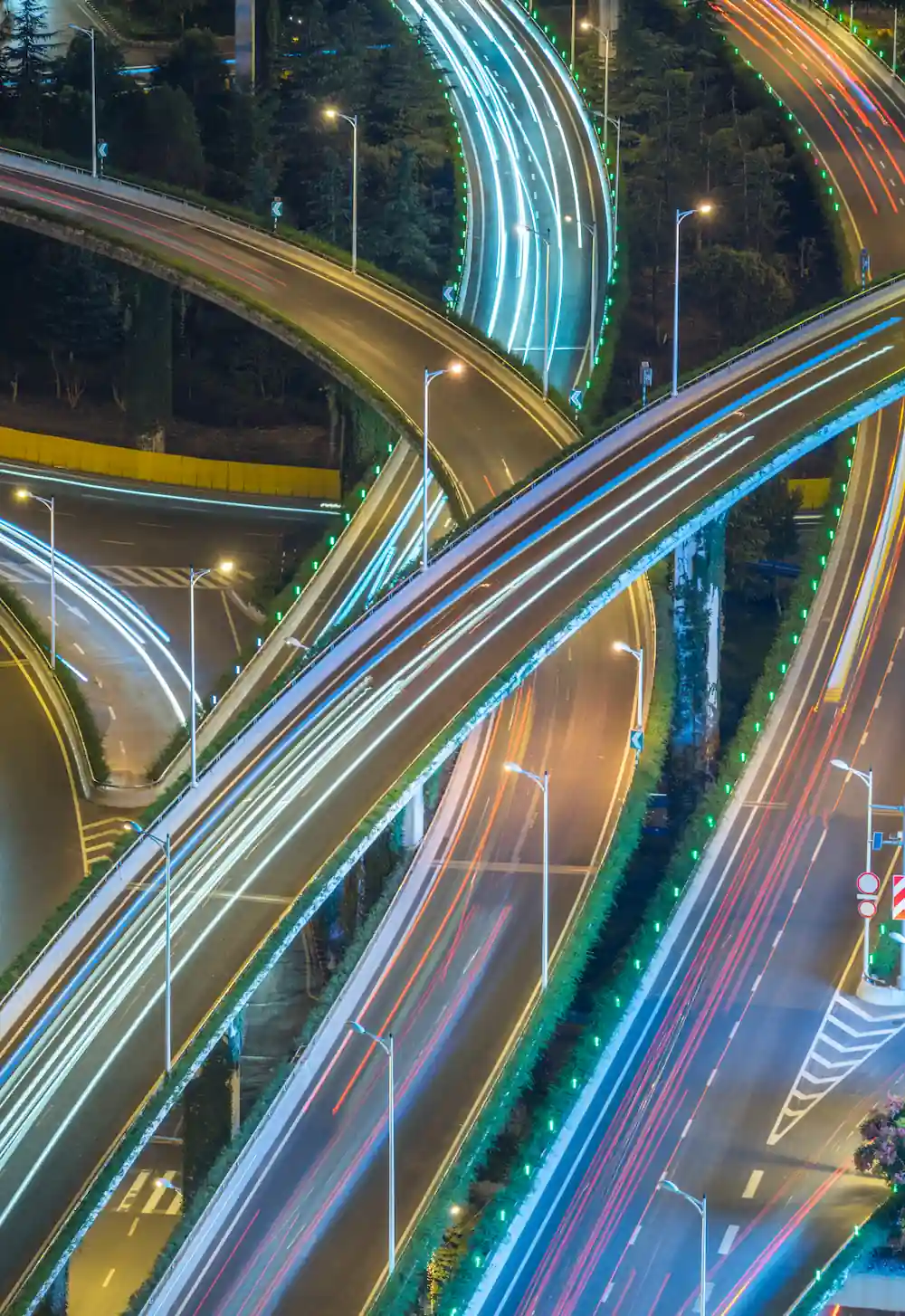 AERIAL VIEW SHANGHAI OVERPASS NIGHT | Cekome Vue nocturne d'un échangeur autoroutier avec des traînées lumineuses de véhicules, illustrant le dynamisme urbain et la mobilité moderne.