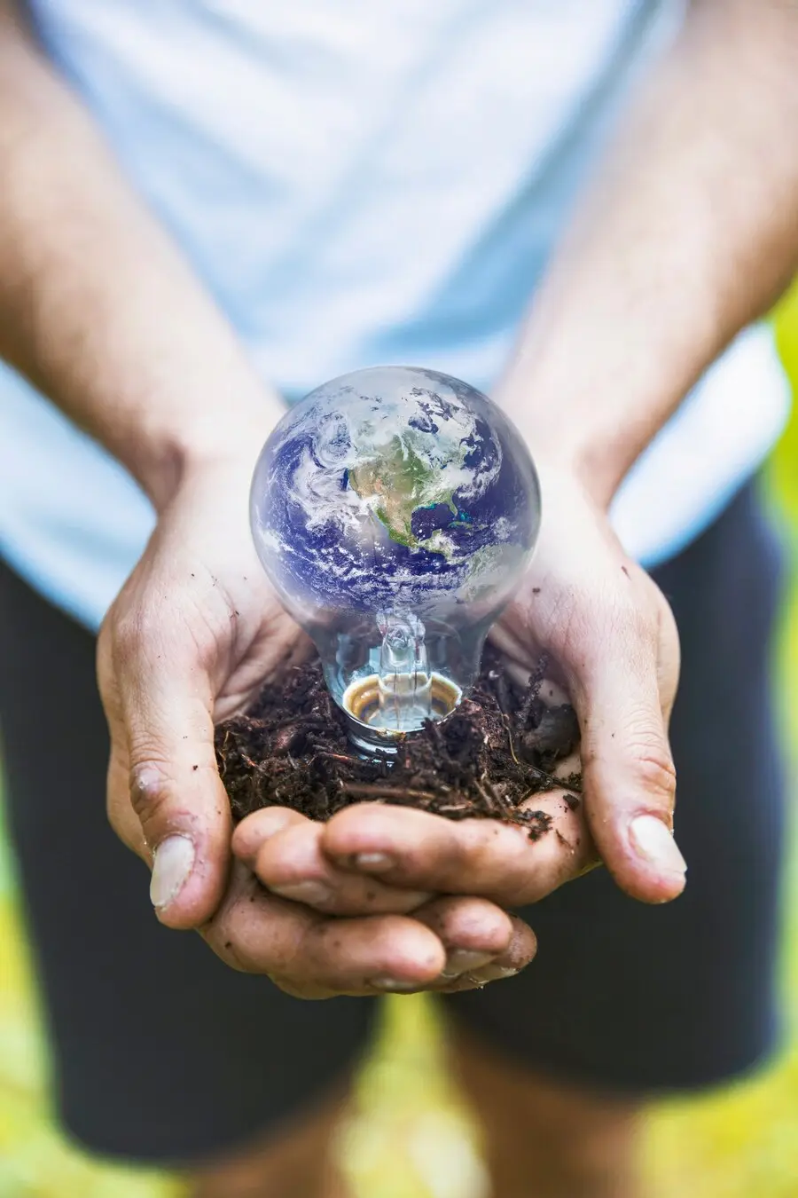 CLIMAT | Cekome Mains tenant une ampoule symbolisant la Terre, représentant l'engagement pour l'écologie et les énergies durables.