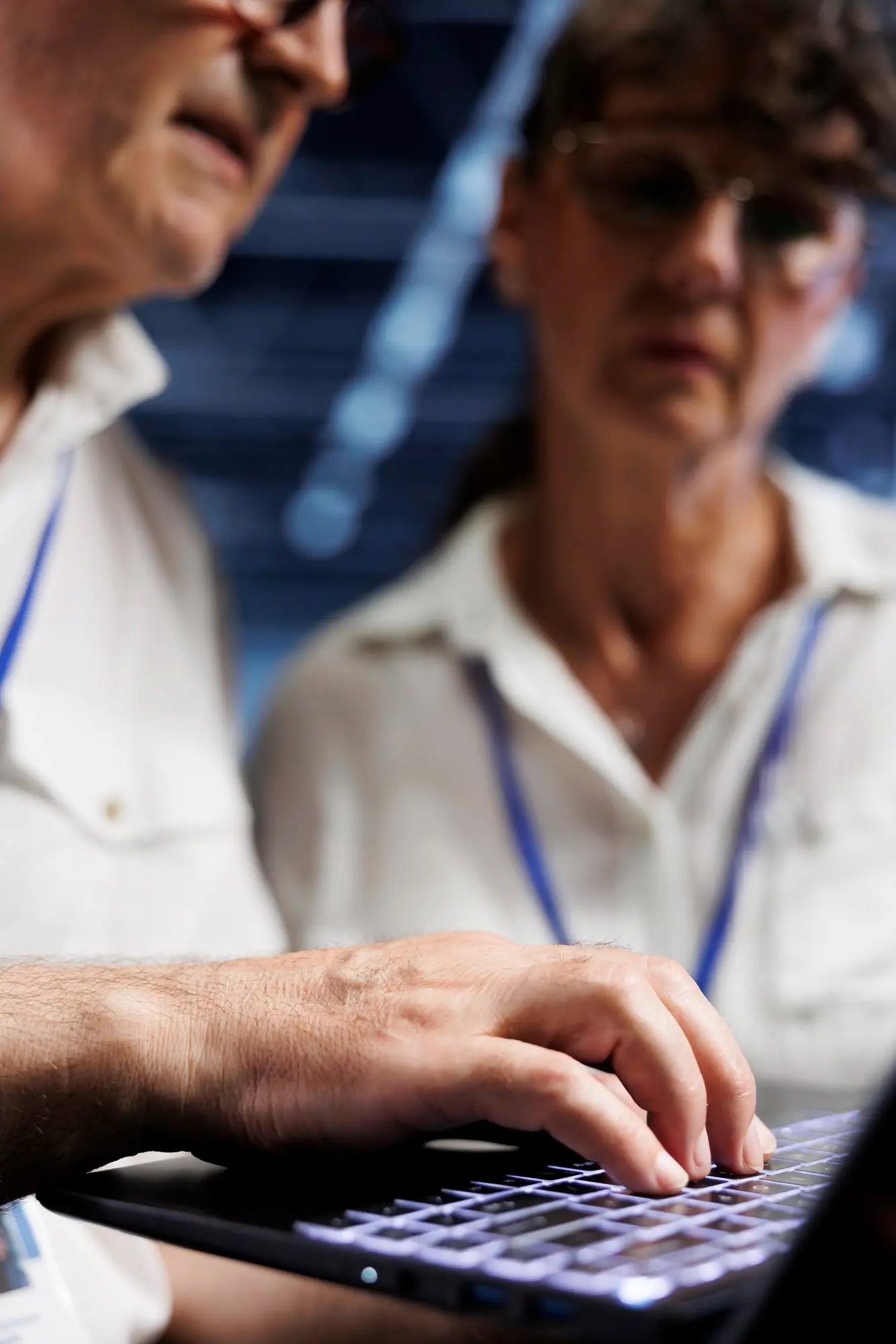 103222 | Cekome Personnes âgées travaillant sur un ordinateur portable, focalisées sur l'écran dans un environnement professionnel