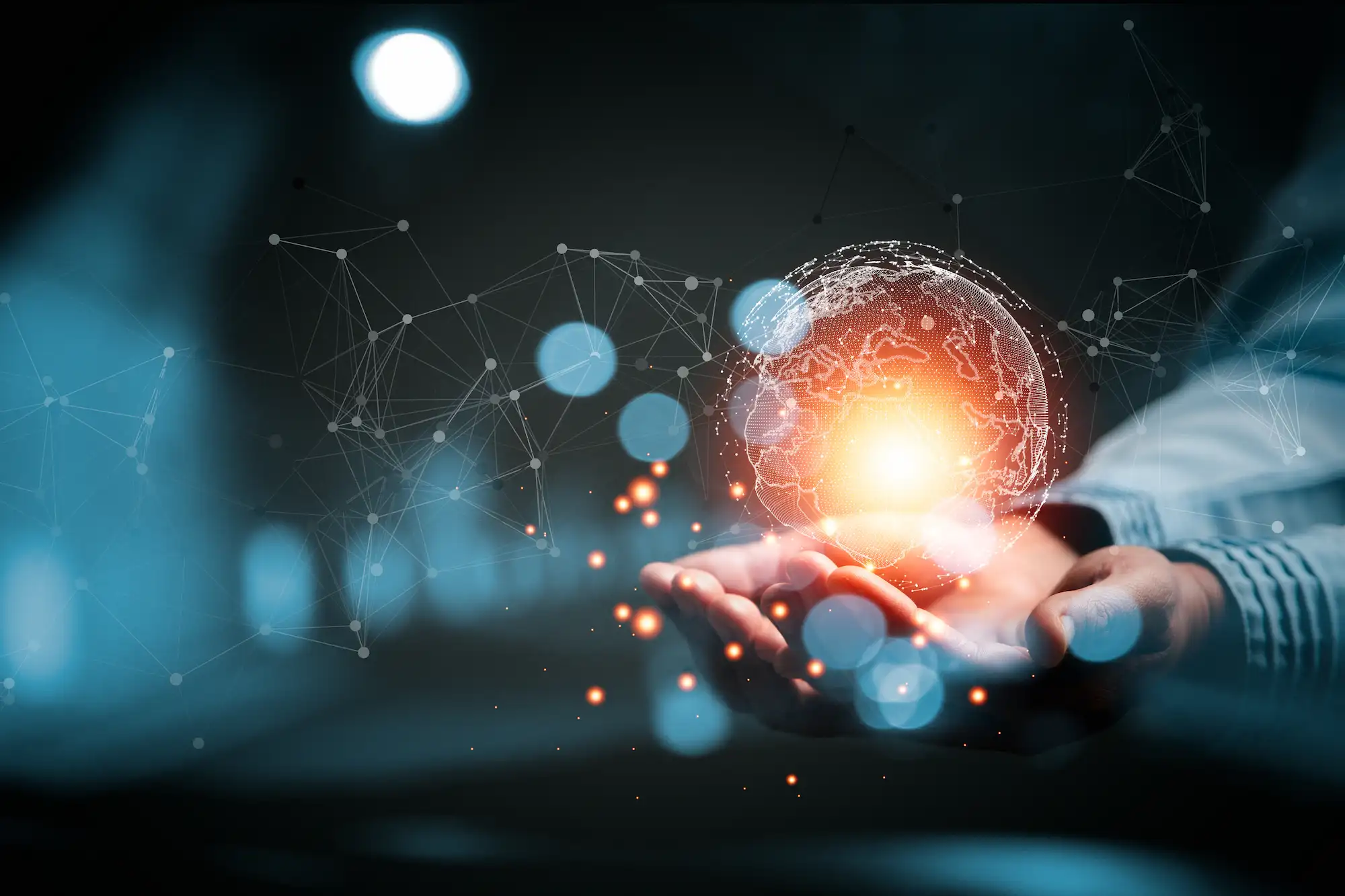 ADOBESTOCK_541647526 | Cekome Mains tenant une sphère lumineuse représentant une planète connectée, symbolisant les réseaux mondiaux d’agents autonomes et l’interconnexion numérique globale