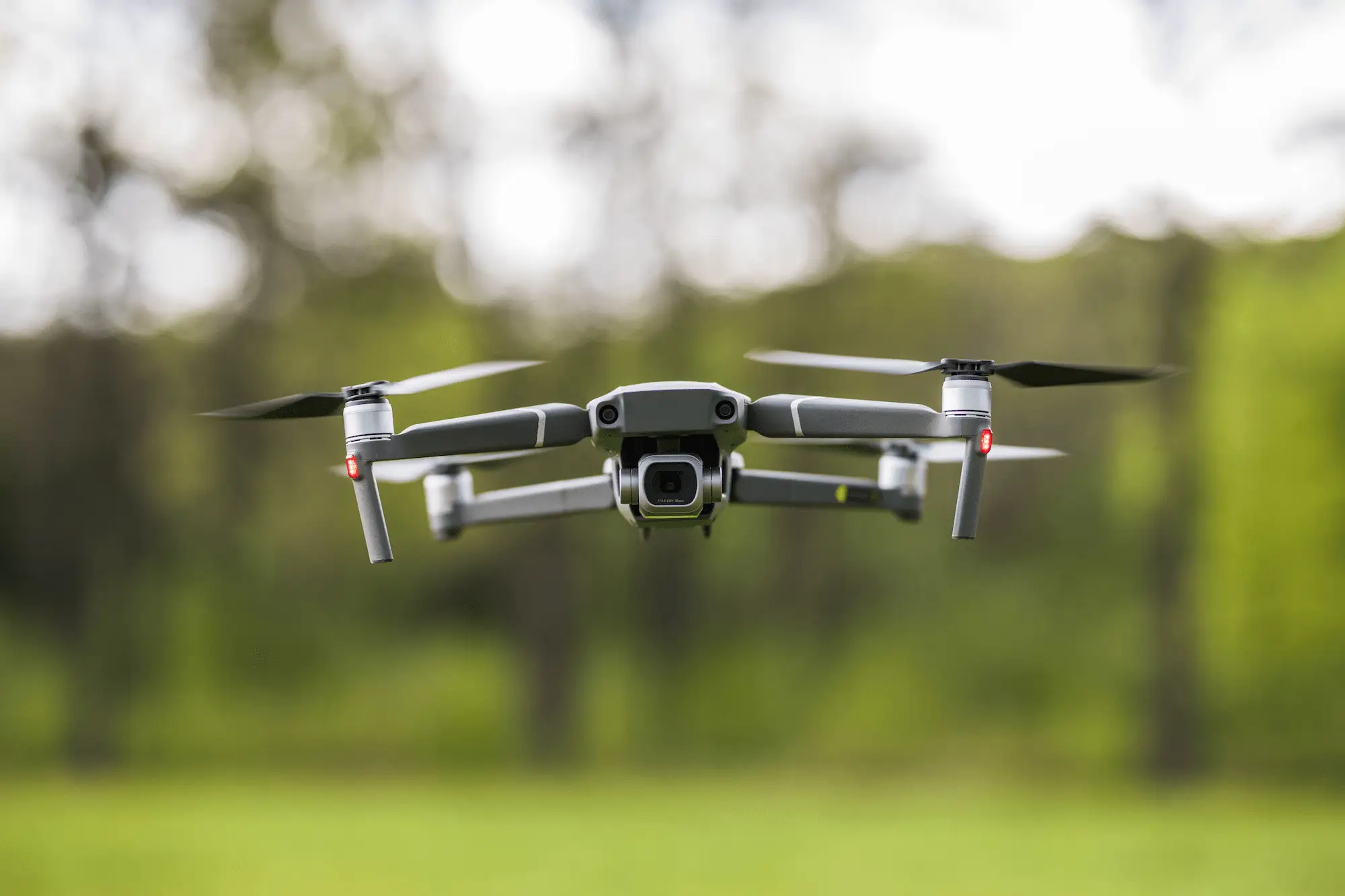QUADCOPTER FLYING NATURE | Cekome Drone quadricoptère en vol stationnaire en pleine nature, représentant un agent autonome moderne en environnement extérieur