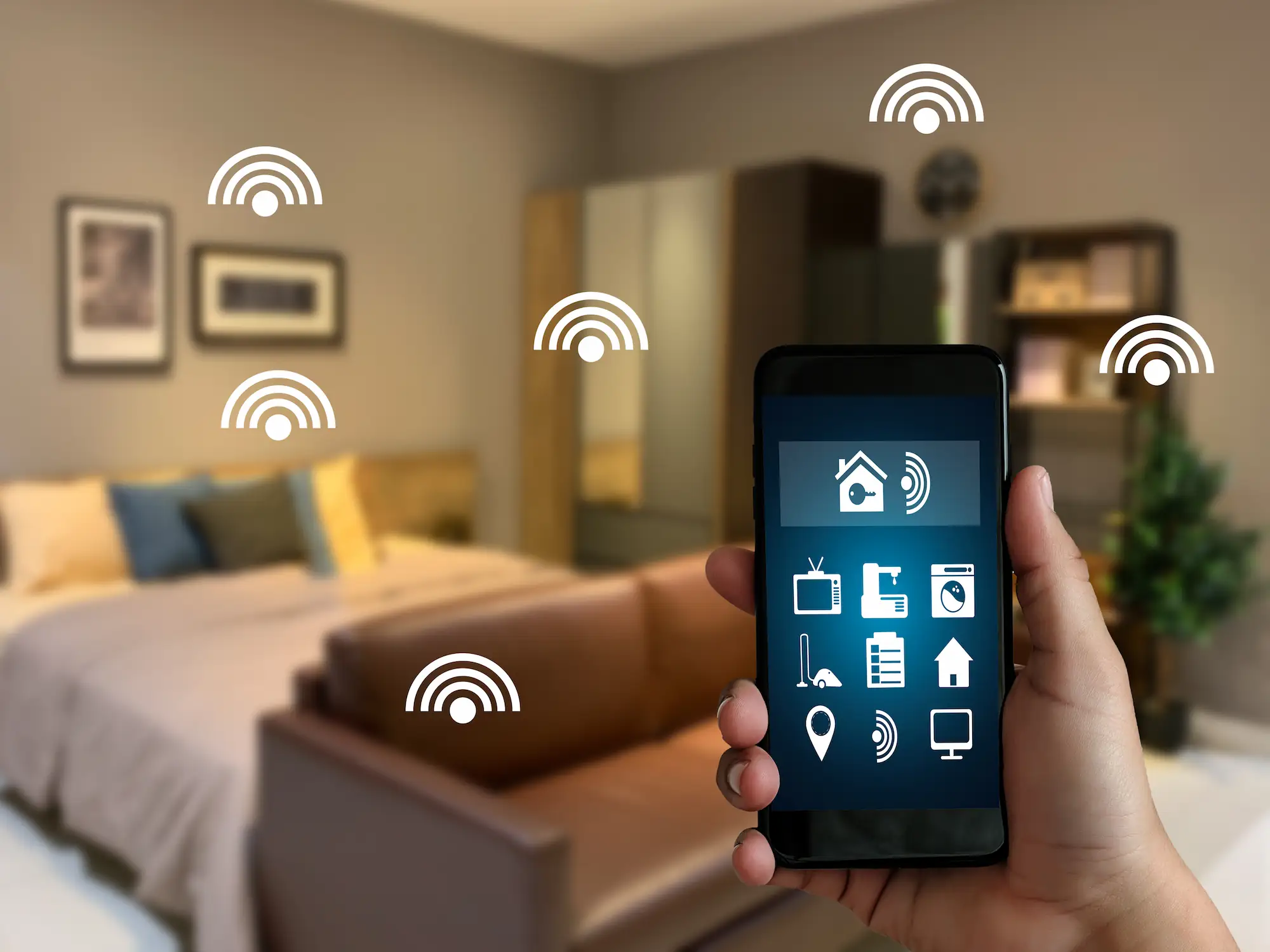 Smartphone contrôlant les objets connectés d’une maison intelligente dans une chambre moderne