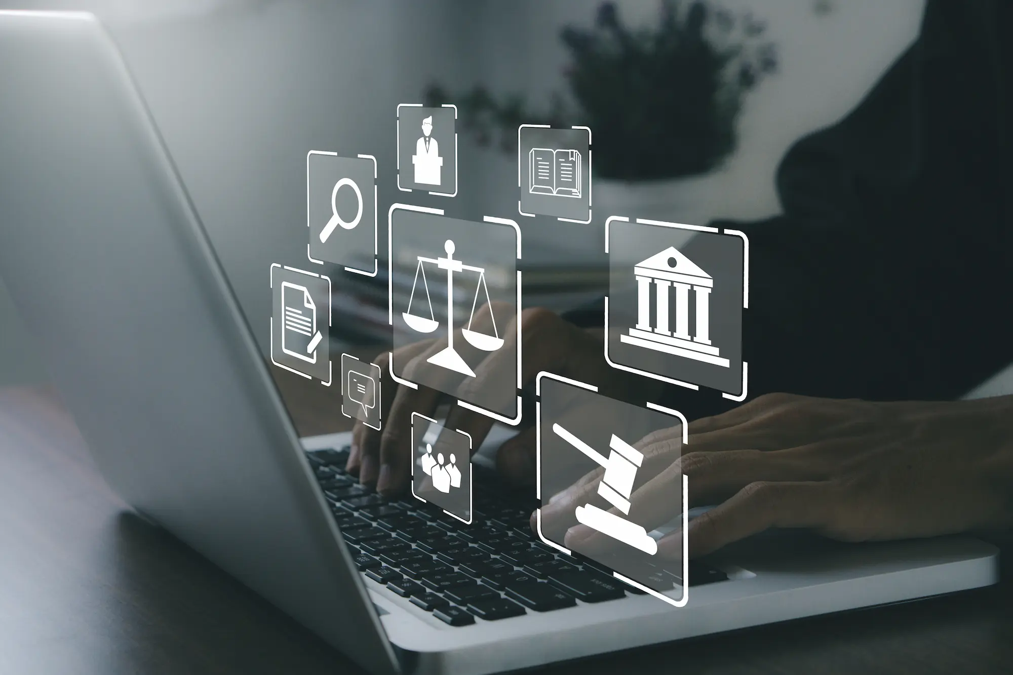 Mains tapant sur un ordinateur portable avec des icônes juridiques en surimpression représentant la justice numérique.