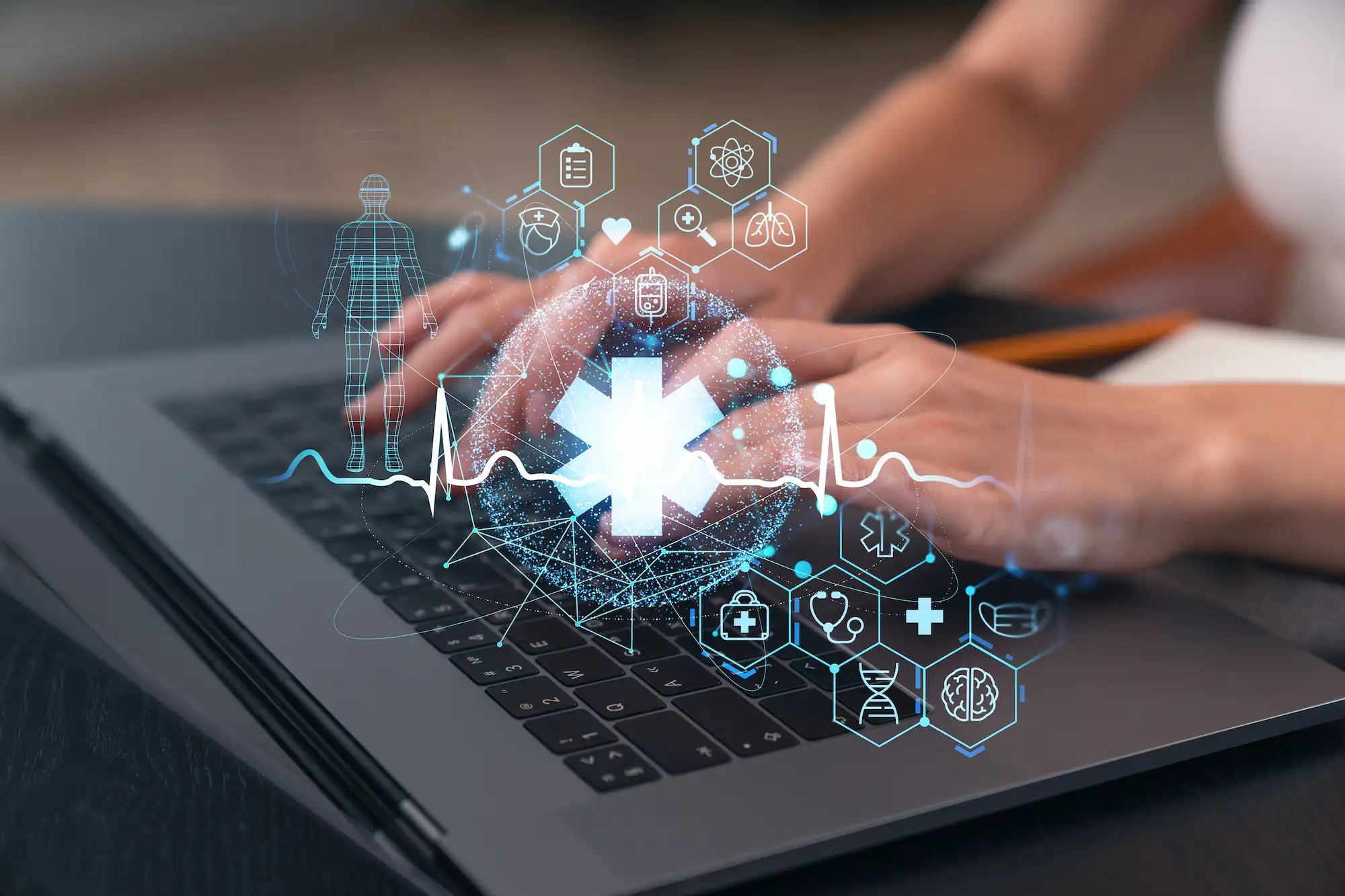 ADOBESTOCK_609532784 | Cekome Mains tapant sur un ordinateur portable avec des icônes de santé connectée et données médicales en réalité augmentée