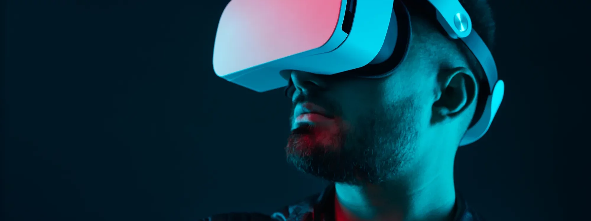 Homme portant un casque de réalité virtuelle dans une ambiance lumineuse bleue et rouge