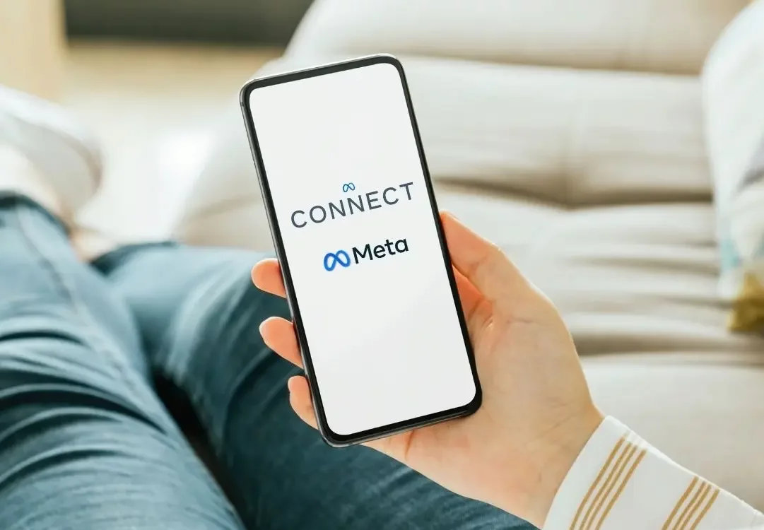 Main tenant un smartphone affichant l’écran de connexion Meta Connect, illustrant l’interaction humaine avec les technologies connectées