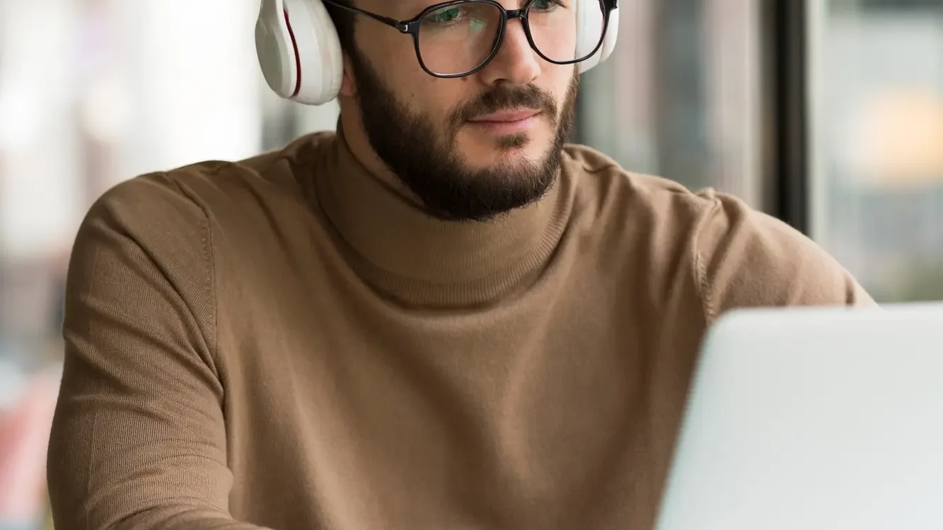 2148446276 1333X750 | Cekome Homme portant un casque audio travaillant sur un ordinateur portable dans un café lumineux