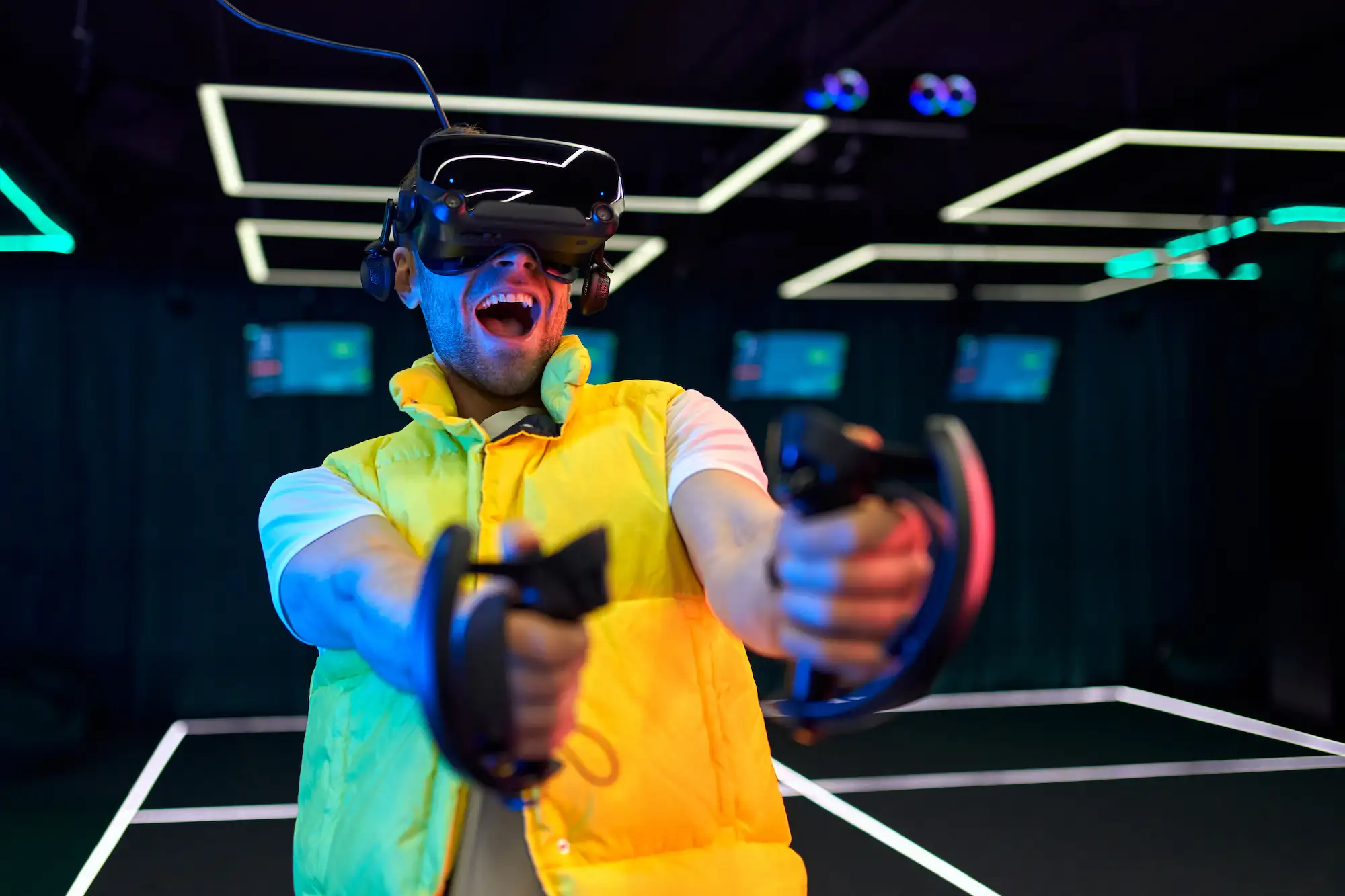 Homme portant un casque VR et tenant des manettes, en pleine immersion dans un jeu en réalité virtuelle.