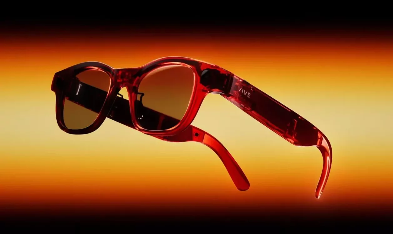 Lunettes de r&eacute;alit&eacute; augment&eacute;e rouges HTC Vive pr&eacute;sent&eacute;es sur fond d&eacute;grad&eacute; orange et noir