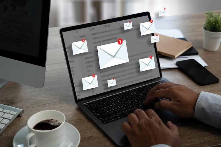 Homme consultant de nombreux nouveaux e-mails affich&eacute;s sur l&rsquo;&eacute;cran d&rsquo;un ordinateur portable dans un bureau