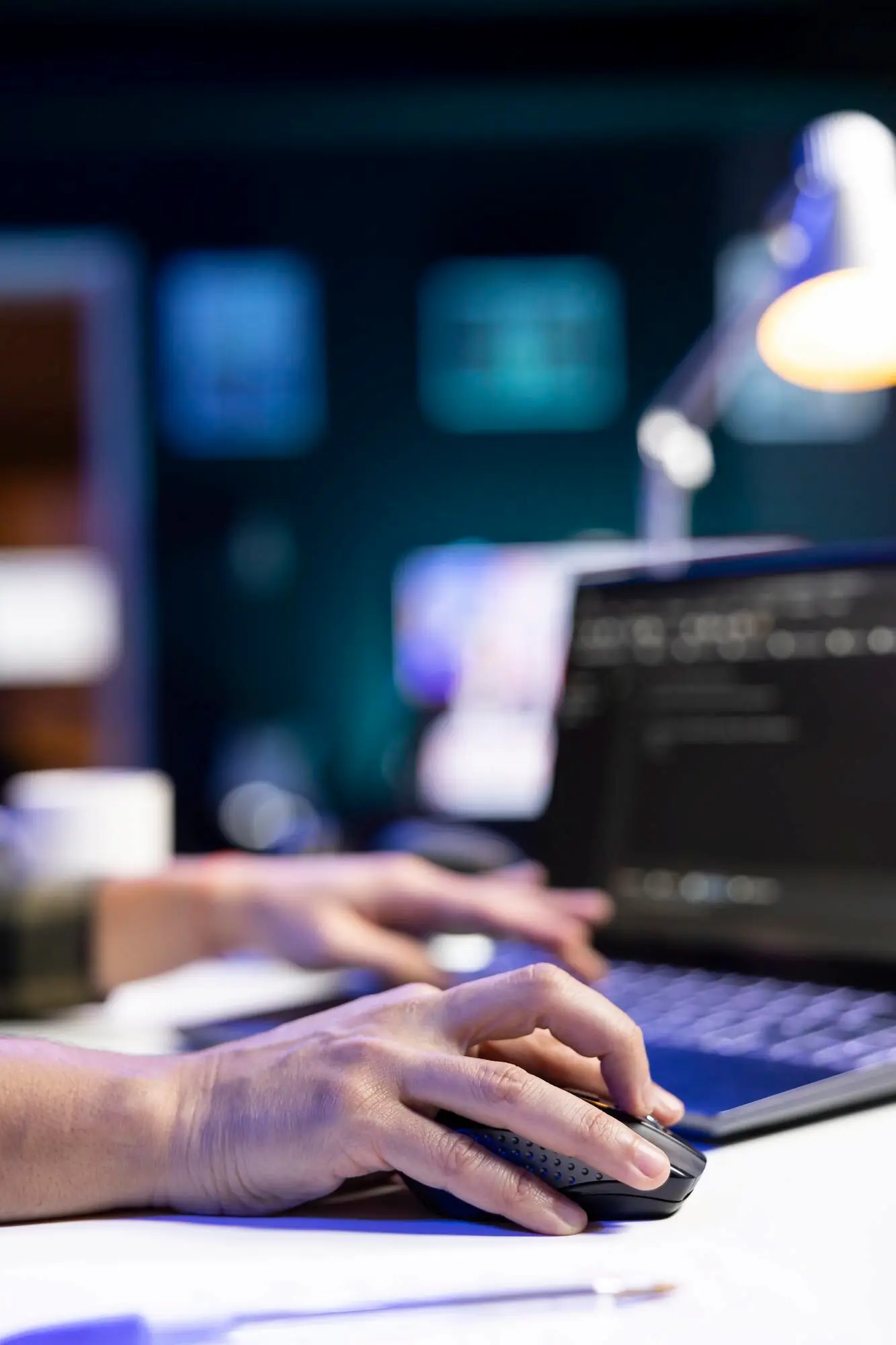 PERSON CODES MANAGES SYSTEM LAPTOP_482257 103688 | Cekome Gros plan sur les mains d’un développeur utilisant une souris et un clavier devant un ordinateur portable affichant du code
