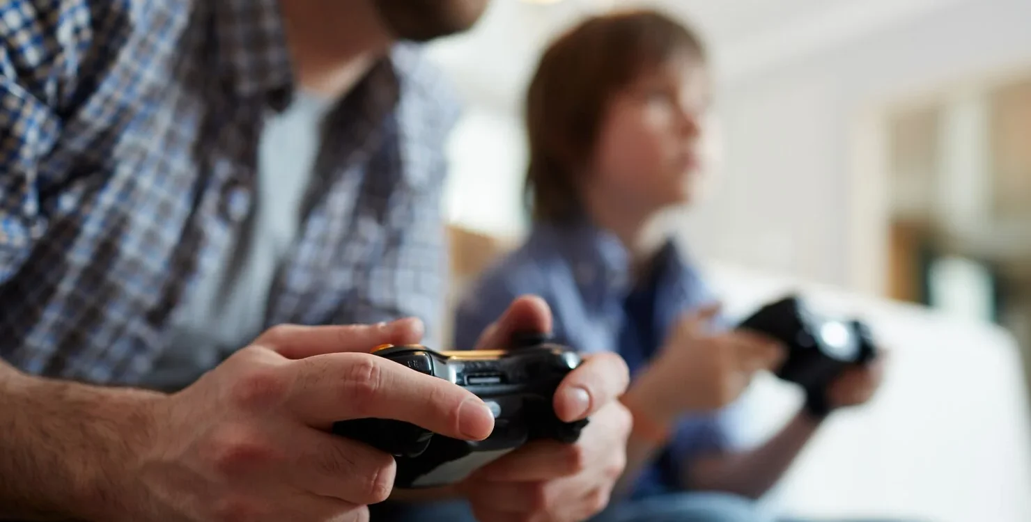 585635552222 1480X750 | Cekome Homme et enfant jouant aux jeux vidéo avec des manettes dans un salon