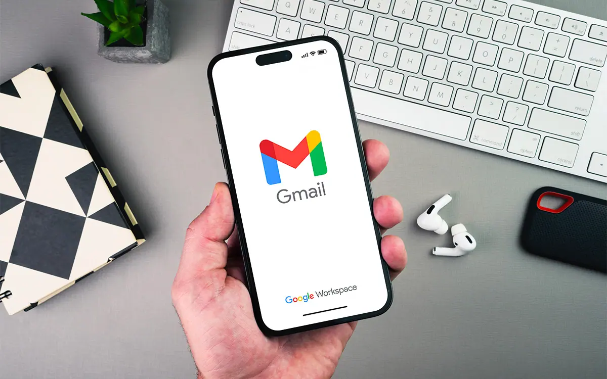 GMAIL GEMINI | Cekome Main tenant un smartphone affichant le logo Gmail avec la mention Google Workspace