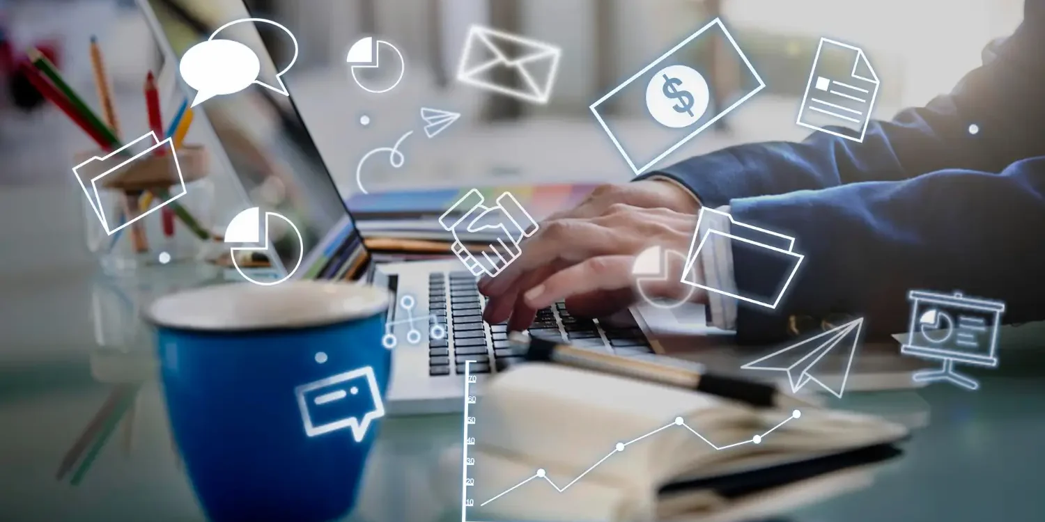 167088 1500X750 | Cekome Mains tapant sur un ordinateur portable avec des icônes numériques flottantes représentant le marketing, la communication et l’analyse de données.