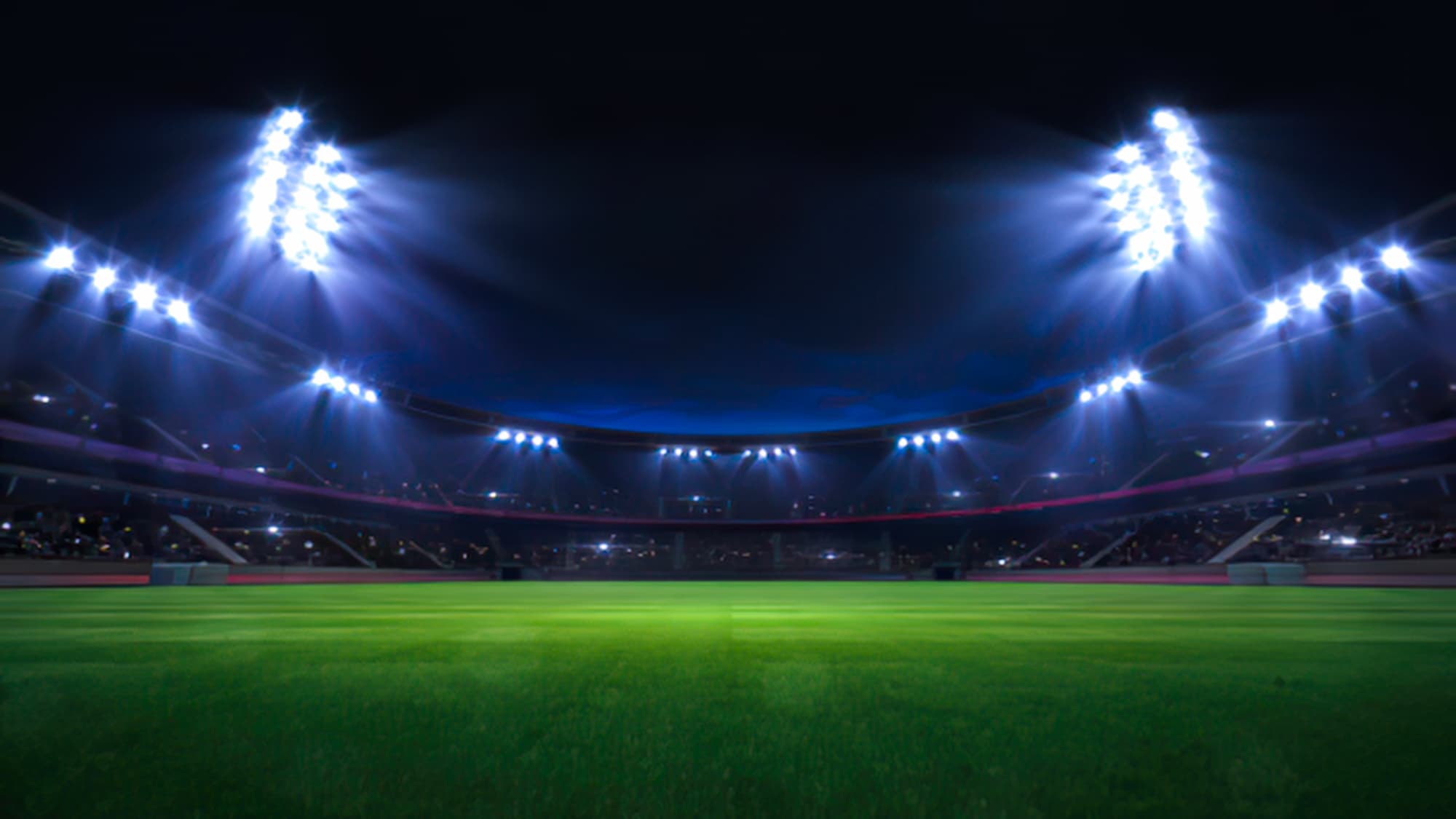 STADE DE FOOTBALL ECLAIRE LA NUIT AVEC GRADINS REMPLIS | Cekome Stade de football éclairé la nuit avec gradins remplis.